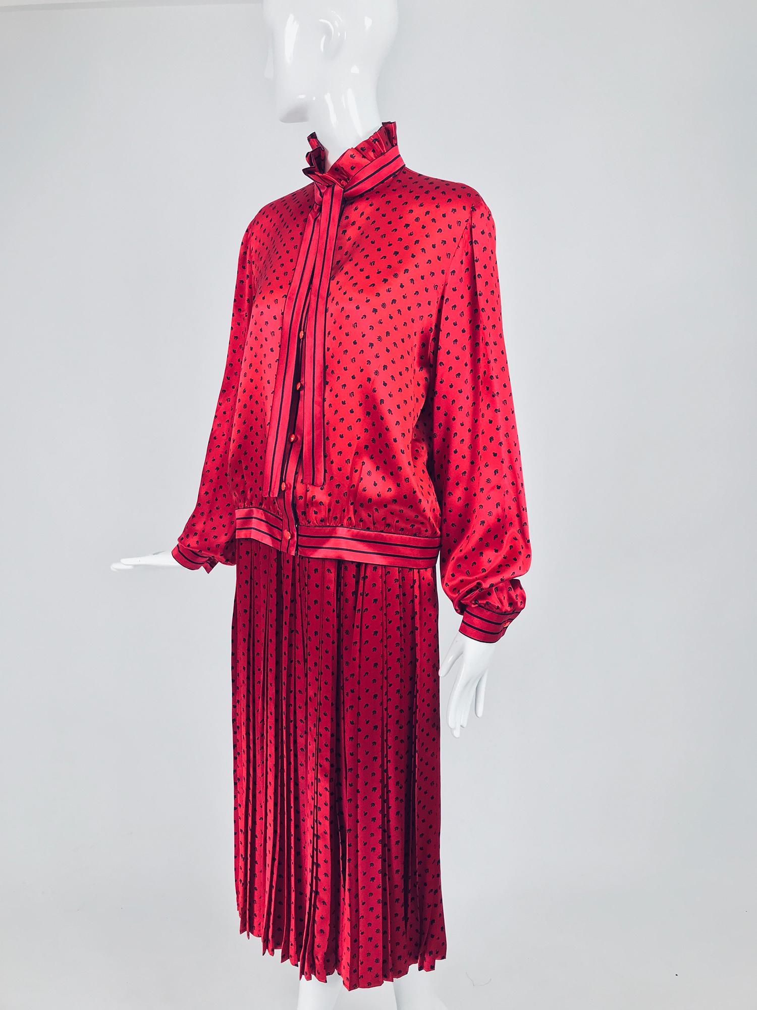 Nina Ricci red silk satin printed blouse and skirt set from the 1980s. Gorgeous candy apple red silk satin is printed with tiny abstract black print. The blouse has a pleated high neckline collar with an attached narrow stripe bow tie. Long full