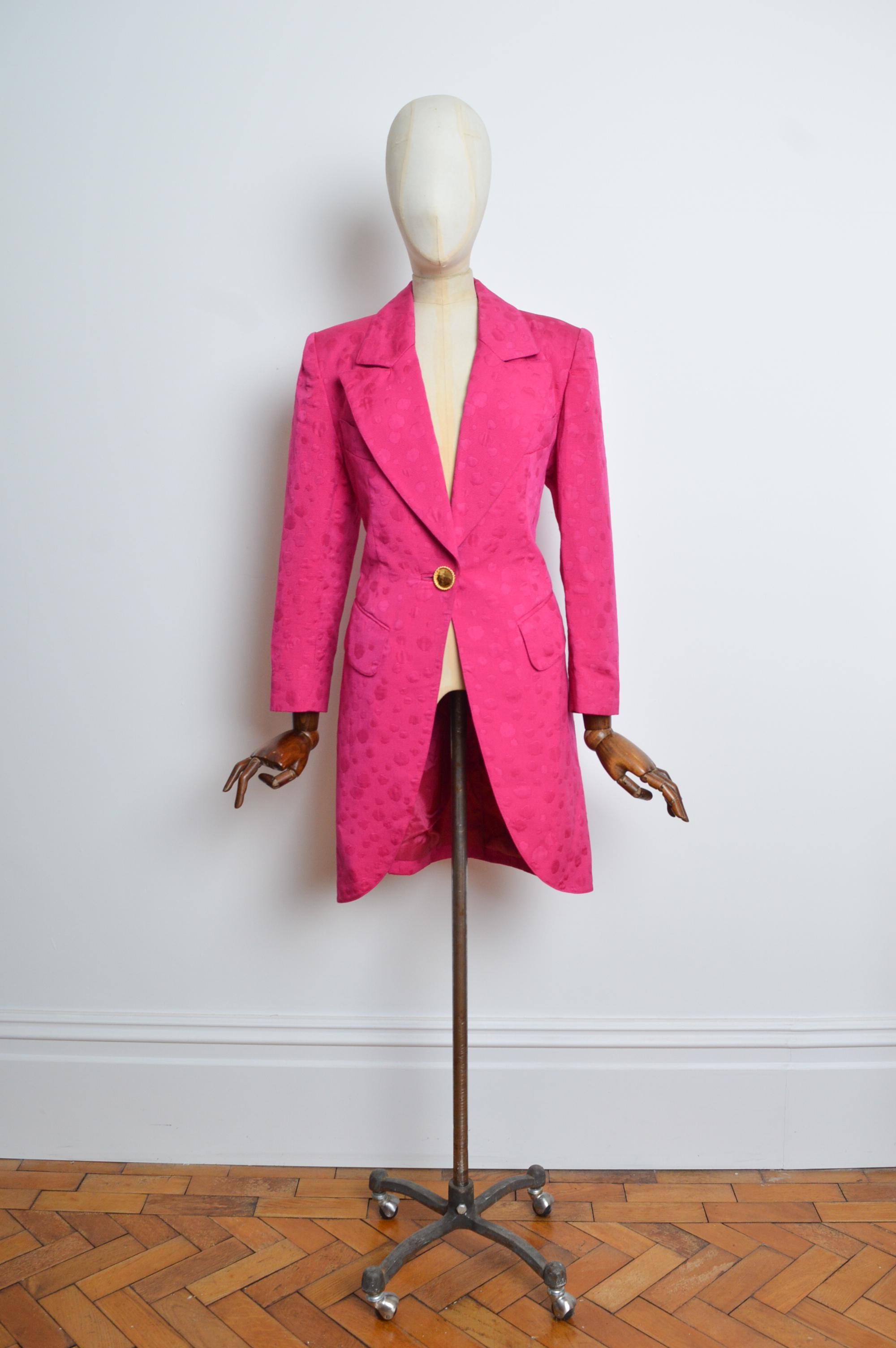Fabelhafter Nina Ricci Smoking-Blazer. Gefertigt aus edlem Shocking Pink gepunktetem, strukturiertem Jacquard. Mit gepolsterten Schultern, markantem Revers, einzigartigem Goldknopfverschluss, Taschen an Brust und Hüfte. 
Größe; EU 38 / UK 10
Die
