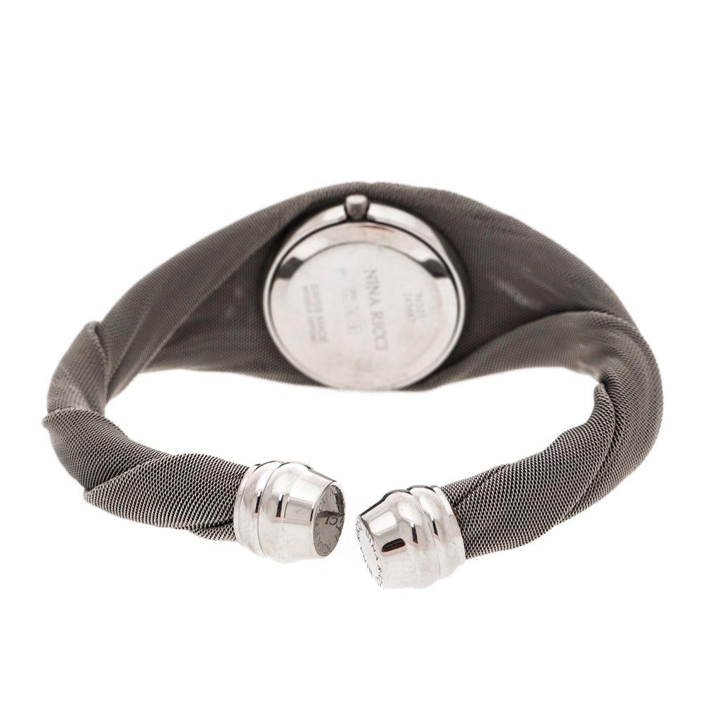 This stunningly-designed creation is from Nina Ricci. In a round stainless steel case, a silver-white dial sits with stud hour markers, two hands a lovely design. Twisted mesh-like bracelet of stainless steel hold the case and can be worn