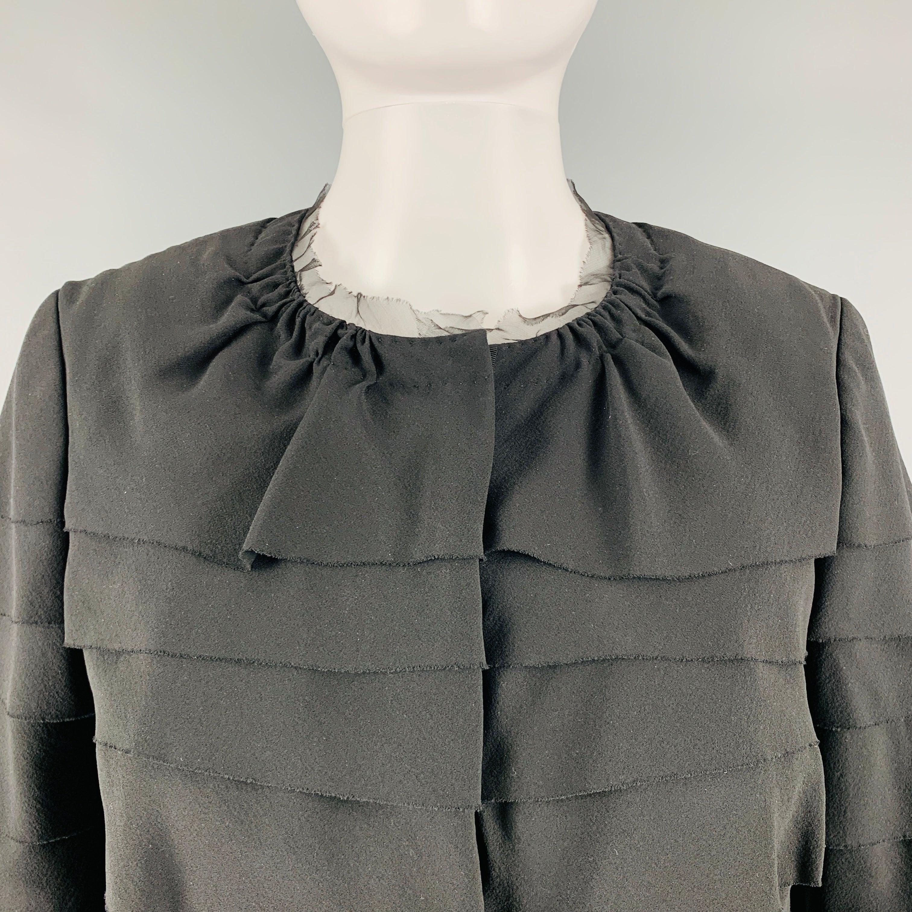 El blazer NINA RICCI se presenta en un tejido de seda negro con un diseño a capas y un cierre con botones a presión. Fabricado en Francia.Excelente estado de conservación. 

Marcado:   6 

Medidas: 
 
Hombros 14,5 pulgadas Busto: 34 pulgadas Manga: