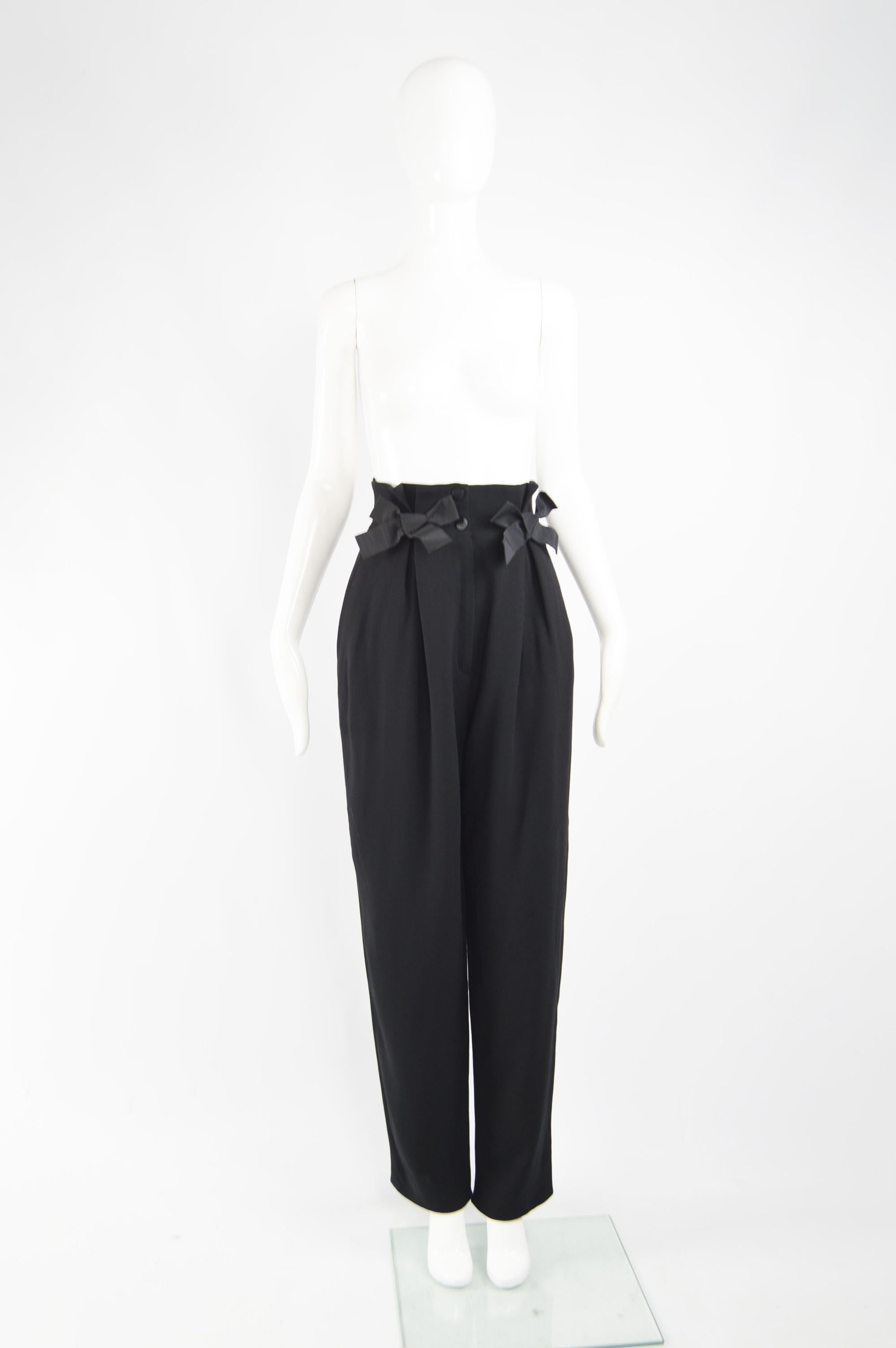 A fabulous pair of womens high waisted trousers from the 80s by luxury French fashion house, Nina Ricci. In a black wool crepe with a high waist and pleats and cute grosgrain ribbons on the front. 

Size: Marked Vintage 42 but fits more like a