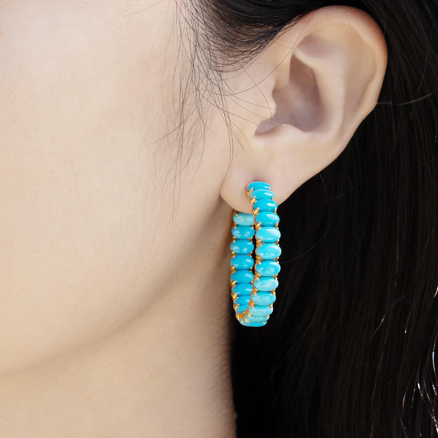 Nina Zhou's 16ct Turquoise Inside-out Hoop Earrings in 14k yellow gold encapsulate vibrant elegance with a modern twist. Crafted meticulously, these stunning hoops showcase richly hued, 10-carat turquoise gemstones set both inside and outside,