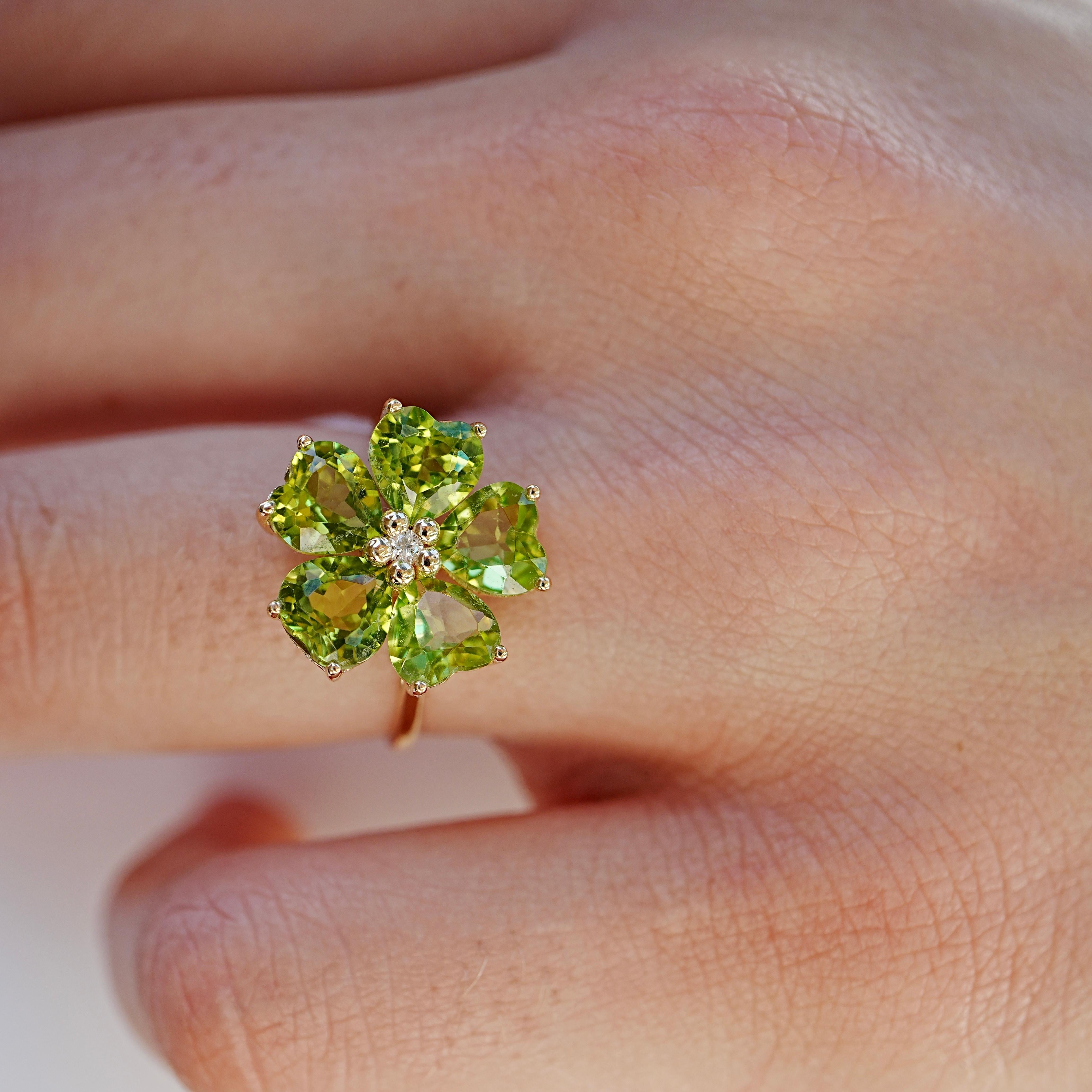 L'anello Nina Zhou 5.00ctw Peridot & Diamond Cherry Blossom Cocktail Ring celebra la freschezza della primavera con uno scrigno di colori naturali. Sei peridoti a forma di cuore sono disposti in un fiore perfetto, i cui toni verdi brillanti sono