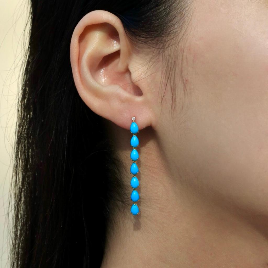 Los Pendientes Colgantes Línea Diamante Turquesa Azul de 5,54 quilates de Nina Zhou, elaborados en lujoso oro amarillo de 14 quilates, ofrecen una impresionante muestra de elegancia y estilo. Estos pendientes presentan llamativas piedras de turquesa