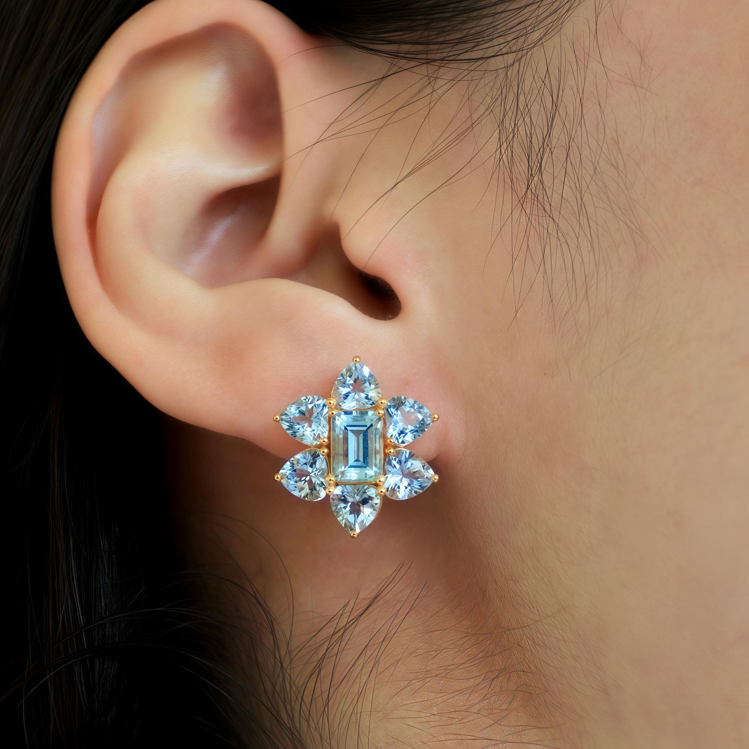 Discover Nina Zhou Emerald Cut and Heart Shape Aquamarine Cluster Earrings in 14k Yellow Gold. The captivating blend of emerald-cut and heart-shaped aquamarine gemstones, showcases a mesmerizing play of light and color. Set in the timeless elegance