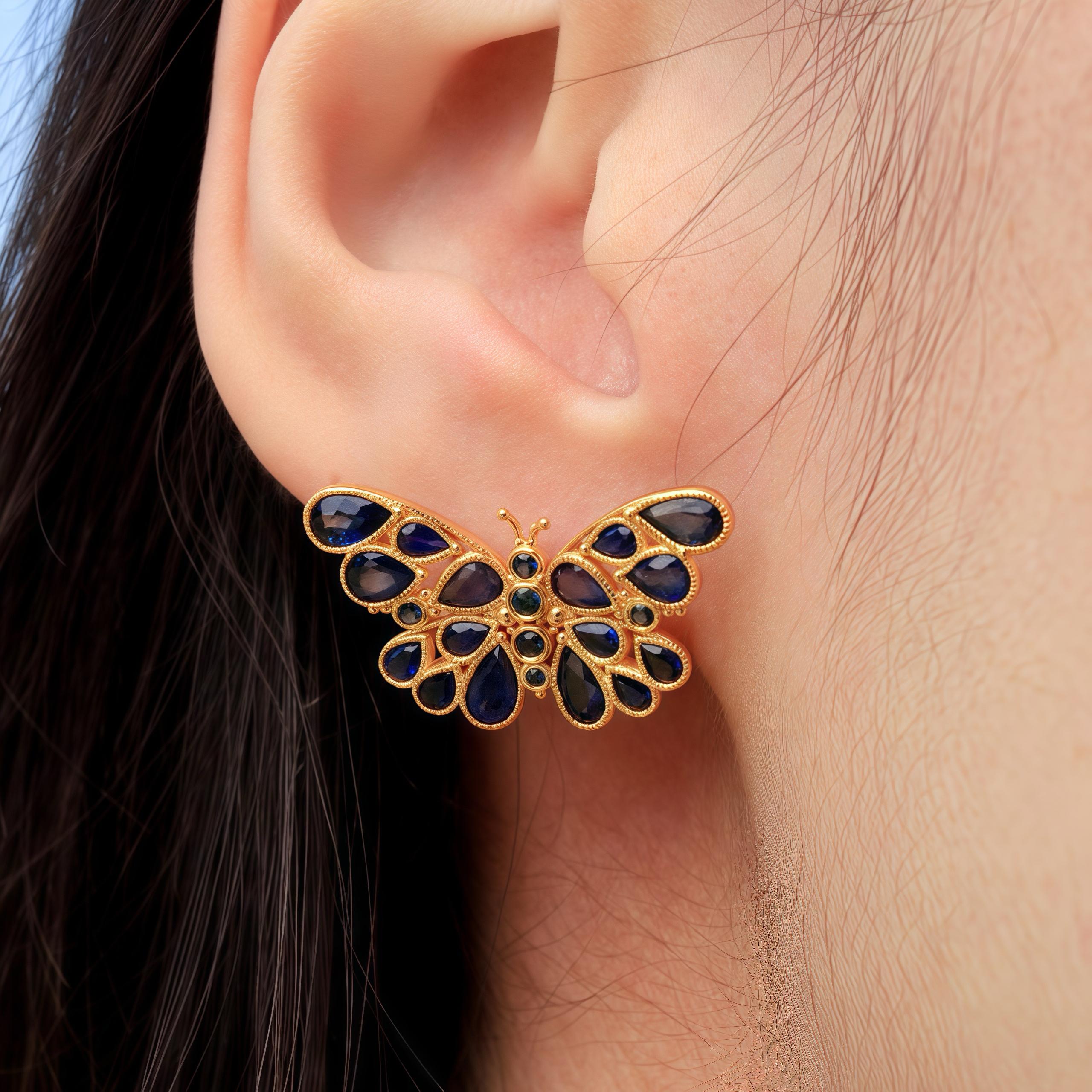 Discover Nina Zhou Butterfly Sapphire Earrings in Yellow Gold. These exquisite earrings feature a delicate butterfly design, adorned with deep blue sapphires that sparkle with every movement. The teardrop-shaped sapphires form the wings of the