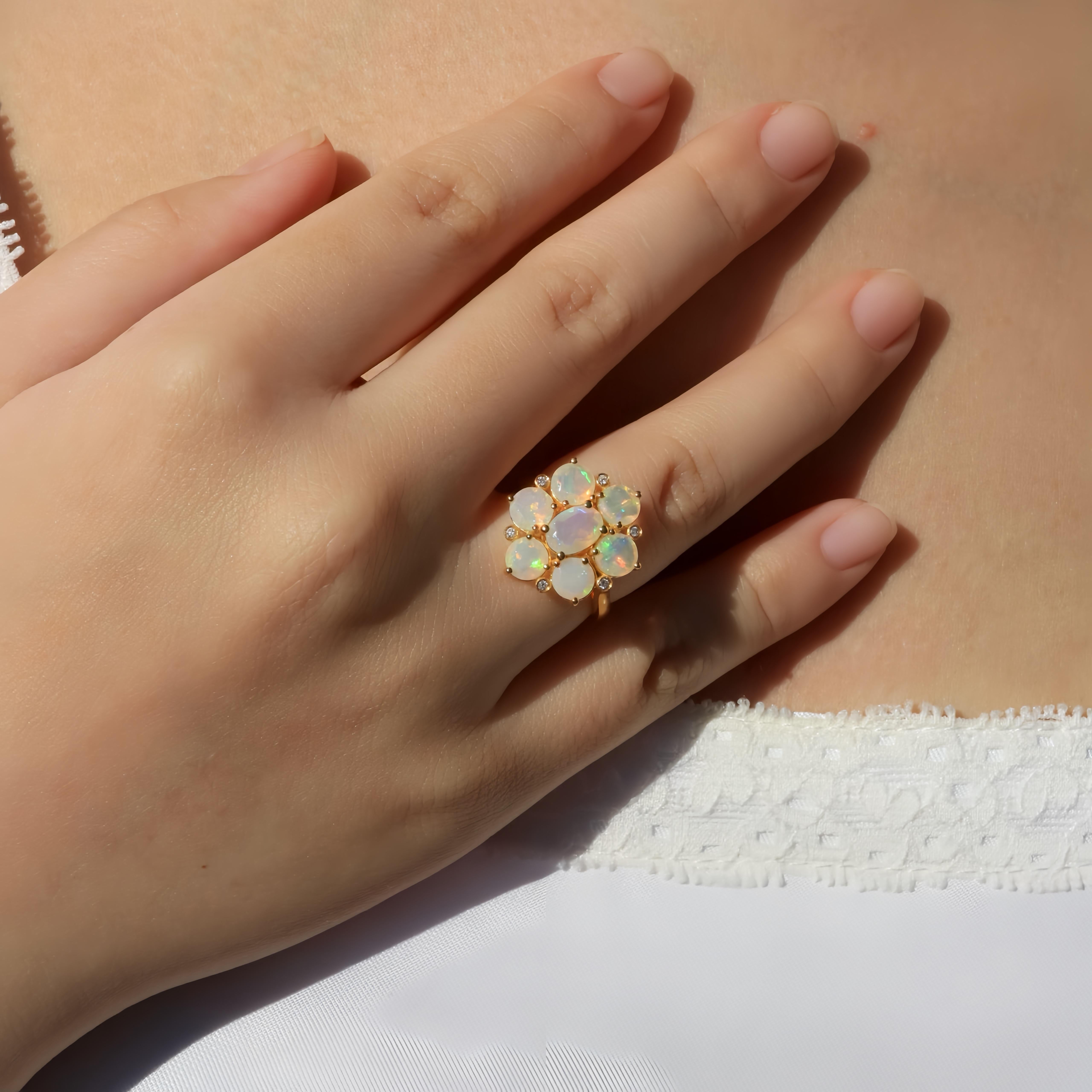 Enthüllen Sie den bezaubernden Glanz des Nina Zhou Celestial Opal Diamond Cluster Ring, ein Meisterwerk, das die ätherische Schönheit von Opalen und die Brillanz von Diamanten einfängt. Dieser aus luxuriösem Gelbgold gefertigte Ring zeigt eine