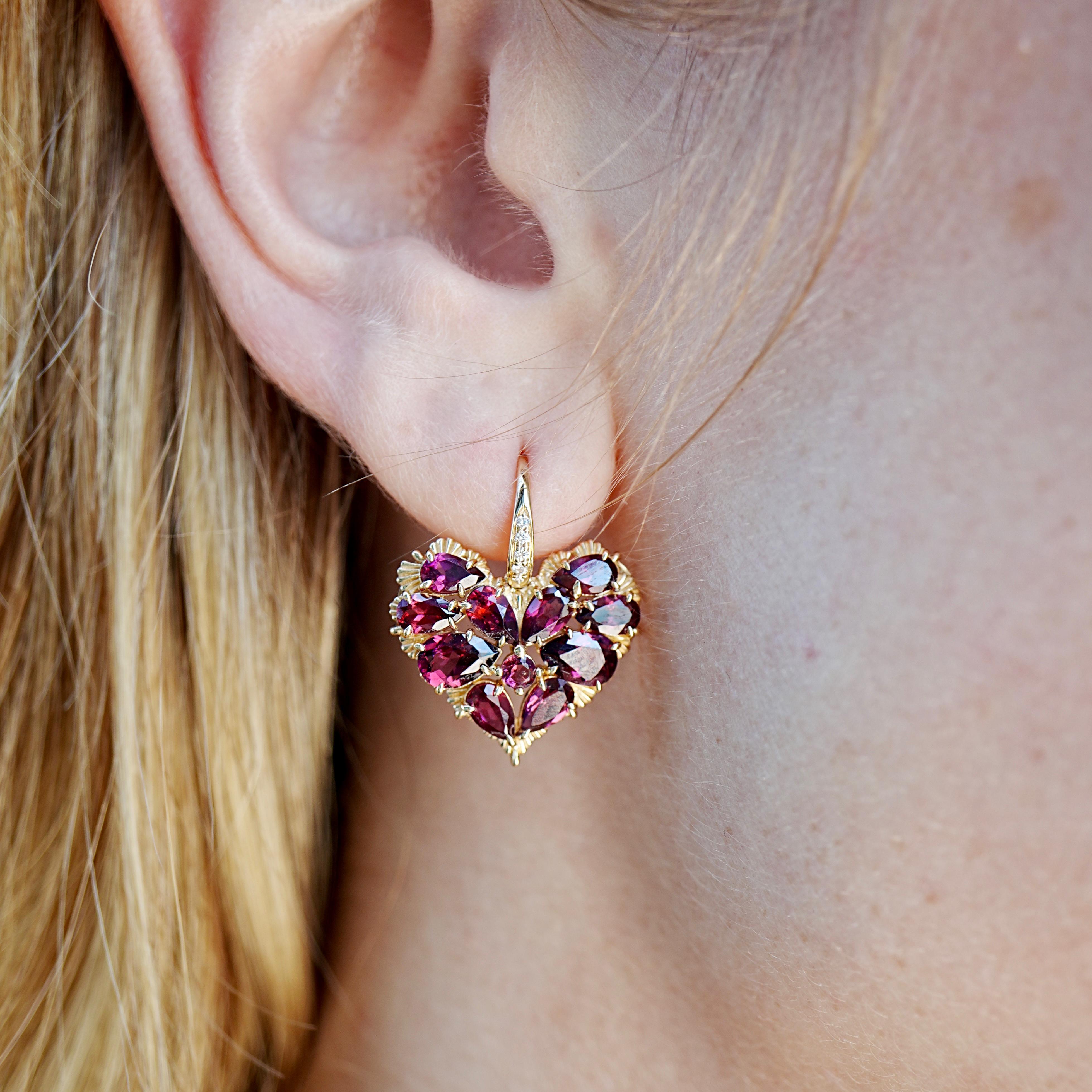 The Nina Zhou Fantasy 6.45ctw Natural Heart Rhodolite & Diamond Drop Earrings radiate romance and artistry in equal measure. Crafted in 14k yellow gold, each earring is formed from clusters of deep pink-red natural rhodolite gemstones cut into