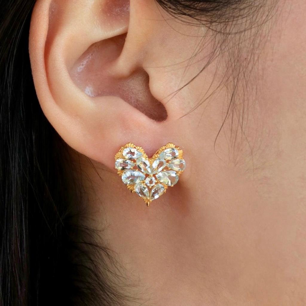 Discover the Nina Zhou Fantasy Aquamarine Heart Earrings, a whimsical expression of romance and artistry. Designed in luxurious yellow gold, these earrings feature exquisite heart-shaped arrangements of glistening aquamarine gemstones, accented with