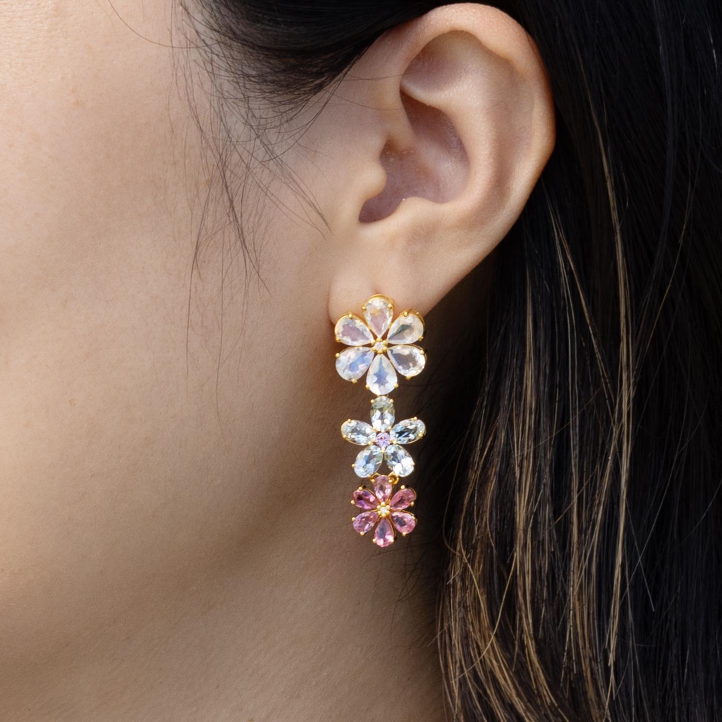 Nina Zhou's Moonstone Aquamarine Pink Sapphire Diamond Blossom Earrings, crafted in 14k yellow gold. These enchanting earrings feature alluring moonstone at the top, renowned for its captivating sheen and the subtle play of light within. Petals of