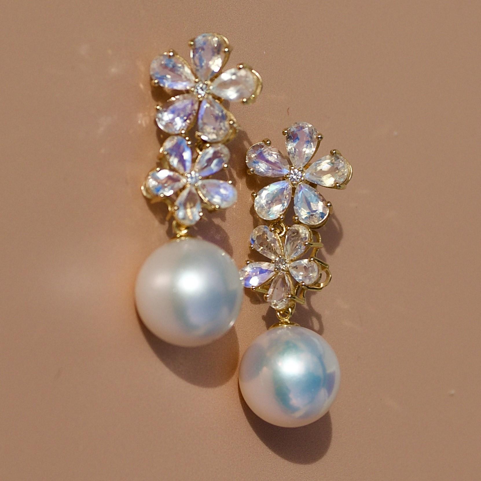Discover Nina Zhou Moonstone Diamond Blossom and 12-13mm Pearl Convertible Drop Earrings in 18k Yellow Gold. These earrings blend the serene glow of moonstones with the timeless sparkle of diamonds, all cradled in a delicate, nature-inspired blossom