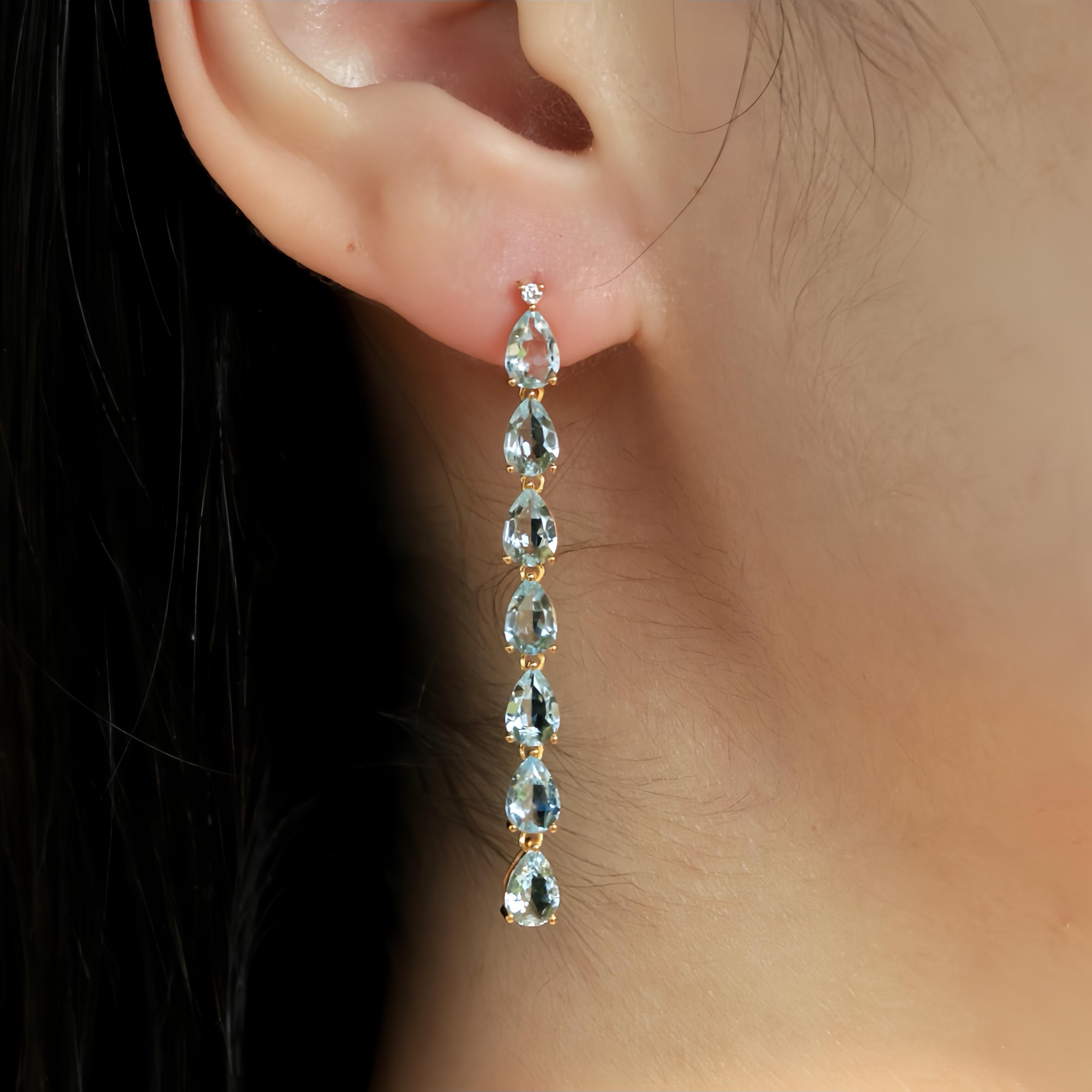 Embrace the subtle elegance and captivating allure of Nina Zhou's Pear Aquamarine Diamond Line Drop Earrings, masterfully crafted in luxurious 14k yellow gold. At the heart of each earring lies a luminous pear-shaped aquamarine, its gentle blue