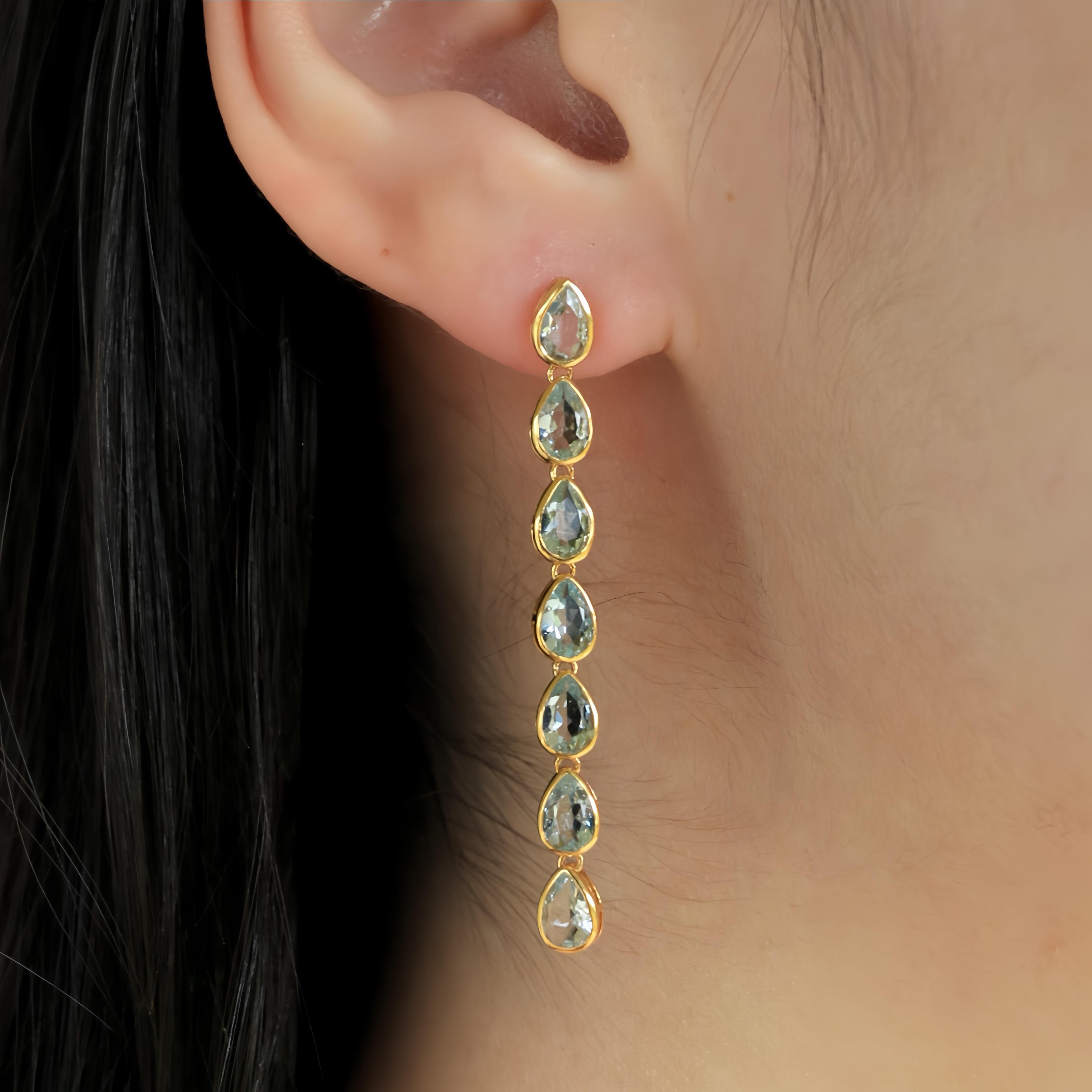Los pendientes en línea de aguamarina azul cielo pera de Nina Zhou, de oro amarillo de 14 quilates, personifican la elegancia y la tranquilidad. Cada pendiente enmarca bellamente una línea de aguamarinas azul cielo en forma de pera, gemas veneradas