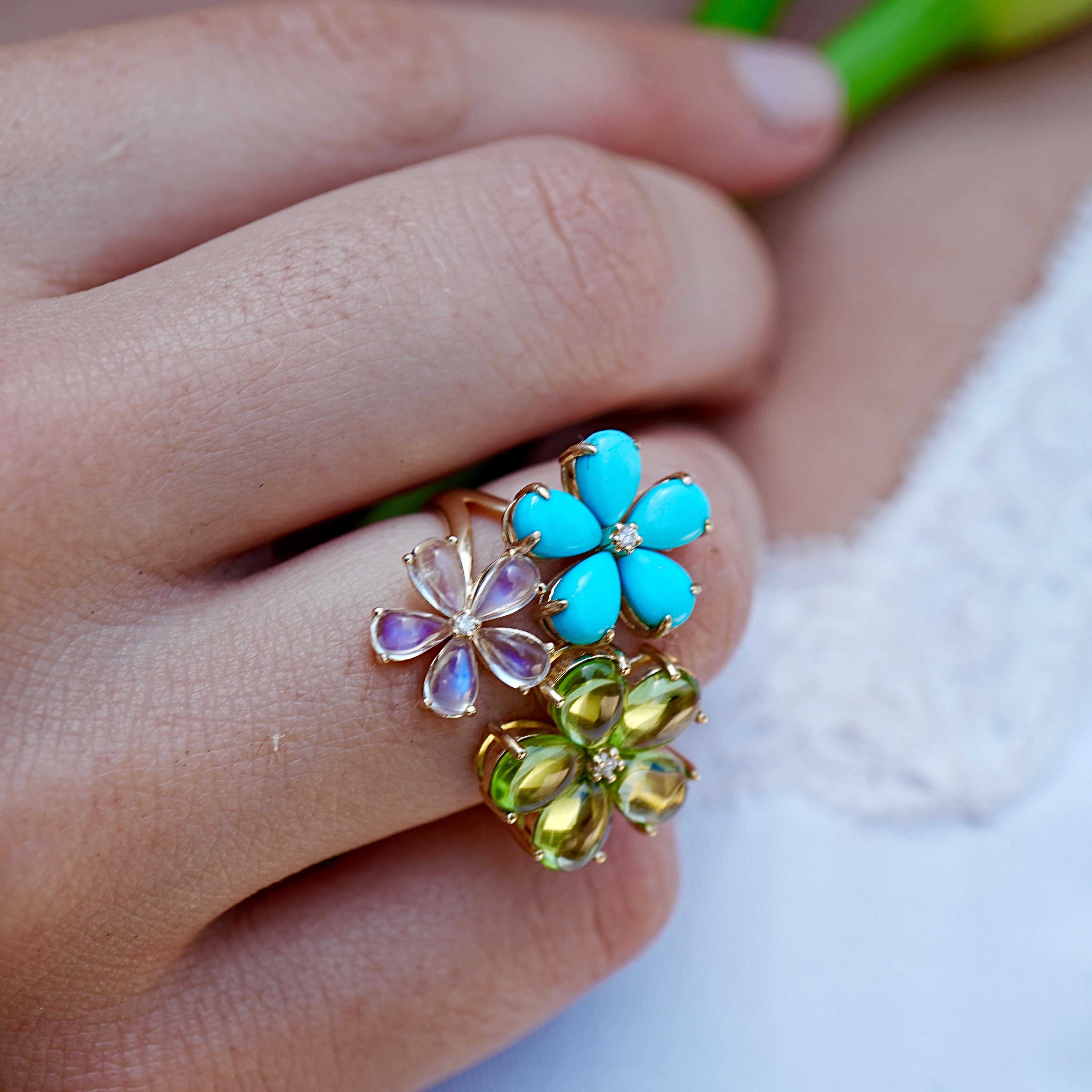 A joyful celebration of color and craftsmanship, this cocktail ring blooms with three flowers in turquoise, peridot, and moonstone—each accented with a diamond center for a subtle sparkle. The floral silhouettes are carved in organic, curved forms