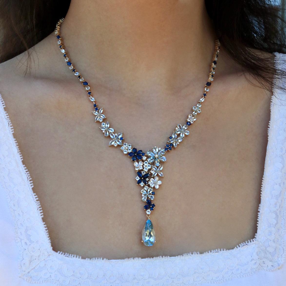Immerse yourself in the elegance of the Symphony Aquamarine Sapphire Statement Necklace, a masterpiece that transforms light and color into wearable art. Featuring a breathtaking arrangement of aquamarines, sapphires, and diamonds, this necklace