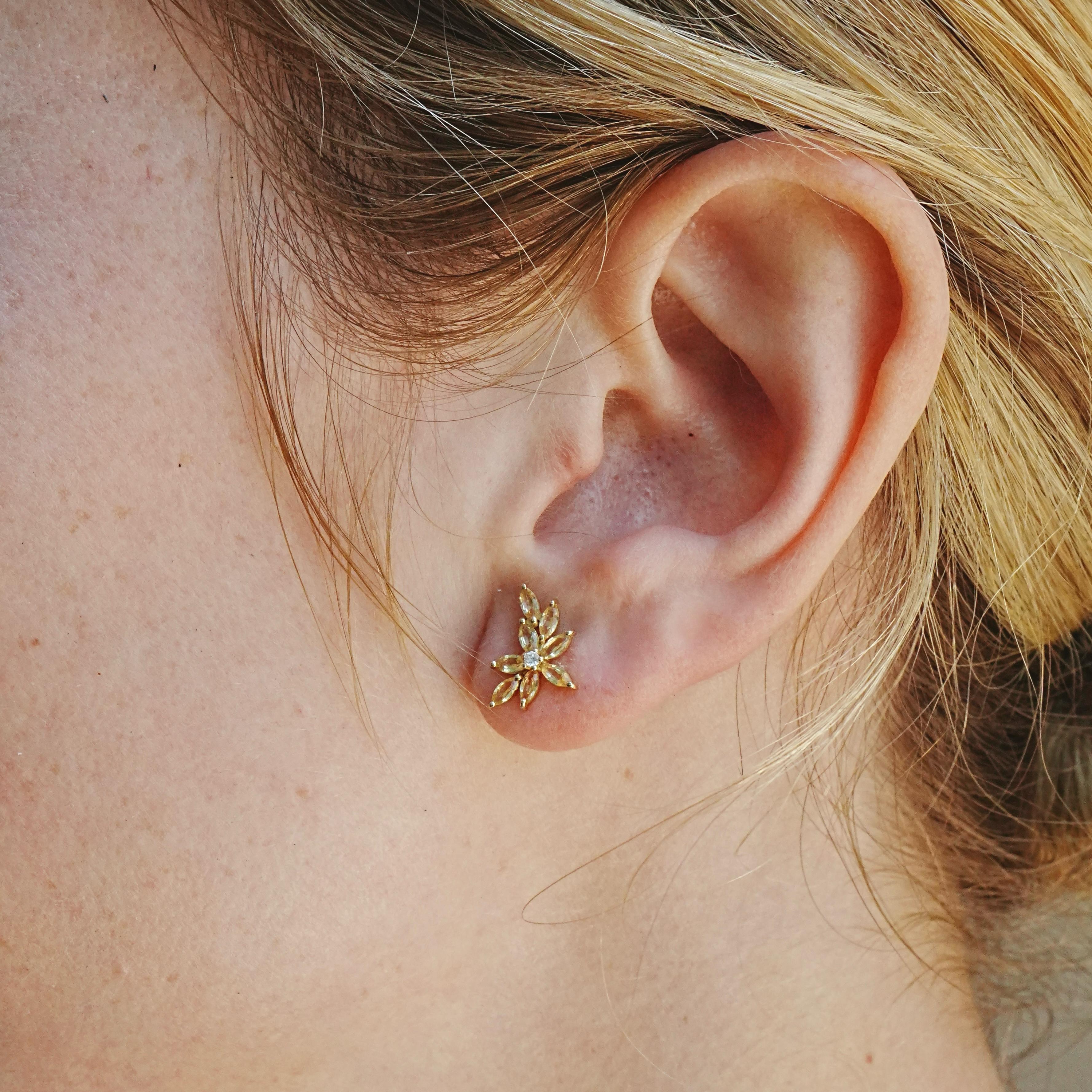 Tels des rayons de soleil capturés dans l'or, ces boucles d'oreilles en grappe de Nina Zhou rayonnent de chaleur et d'éclat grâce à leurs saphirs jaunes taillés en marquise et à leurs diamants naturels sertis au centre. Chaque pierre précieuse est