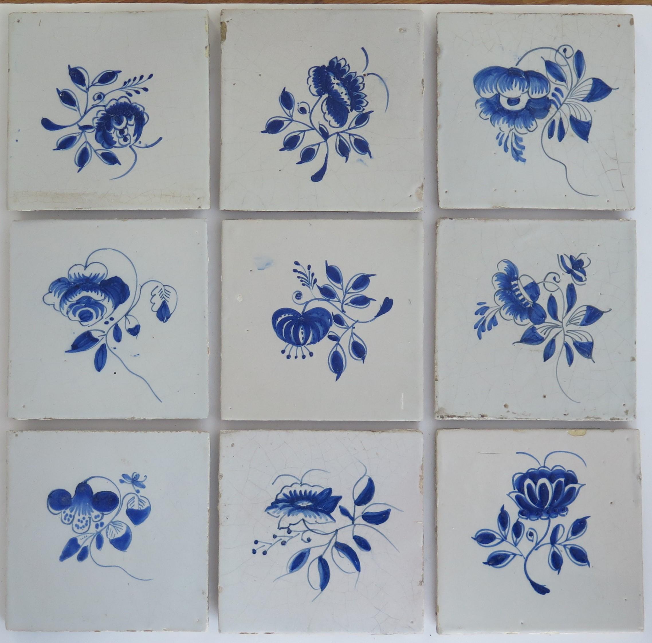 These are nine Delft ceramic wall tiles, all with a blue and white hand painted flower pattern, made in the Netherlands during the 18th century, circa 1750.

Each tile is nominally 5 inches square..

All nine tiles are unique, being individually