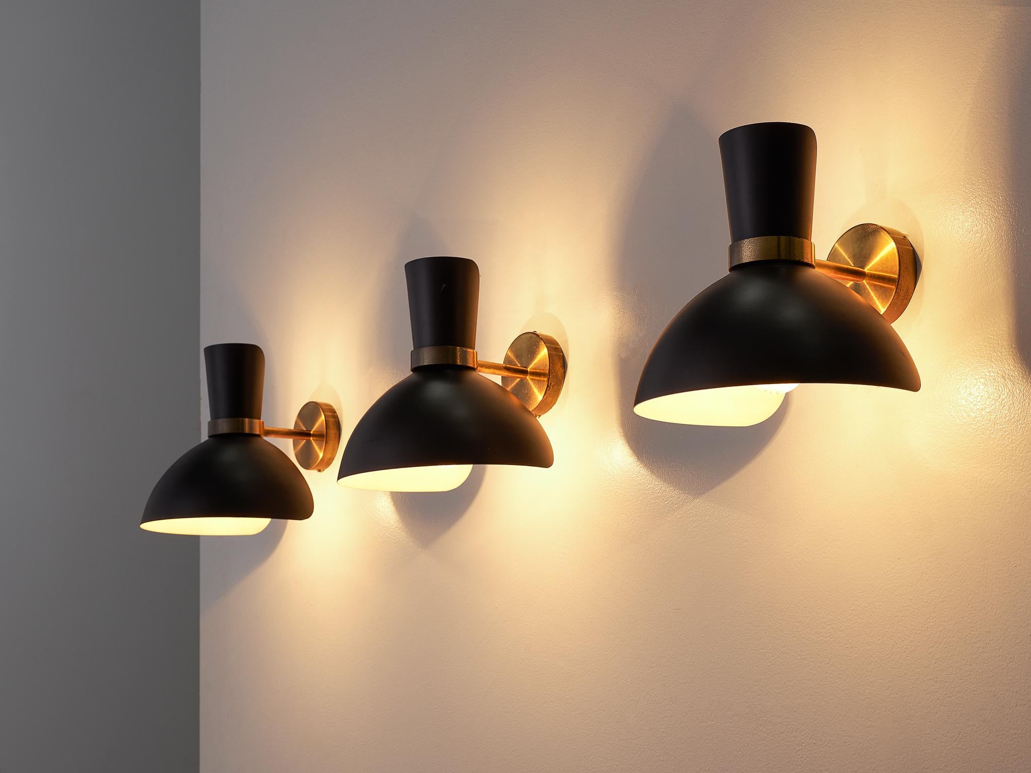 Set of wall lights, brass stem and black coated shade, Scandinavia, 1960s. 

These wall lights feature a classic shade in black with a round brass stem. The brass features a delicate patina that contributes to the warm, elegant design of these