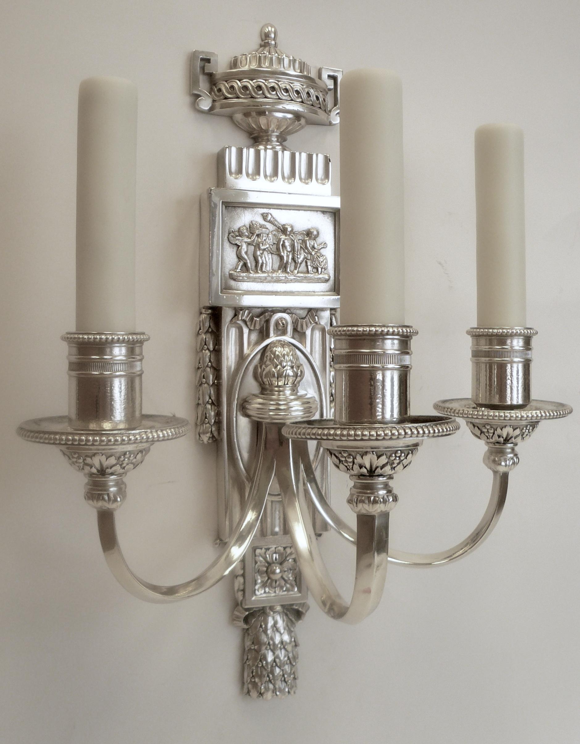 These handsome Caldwell sconces feature neoclassical motifs including acanthus and laurel leaves, urns and swags, and Robert Adam style plaques with mythological scenes.