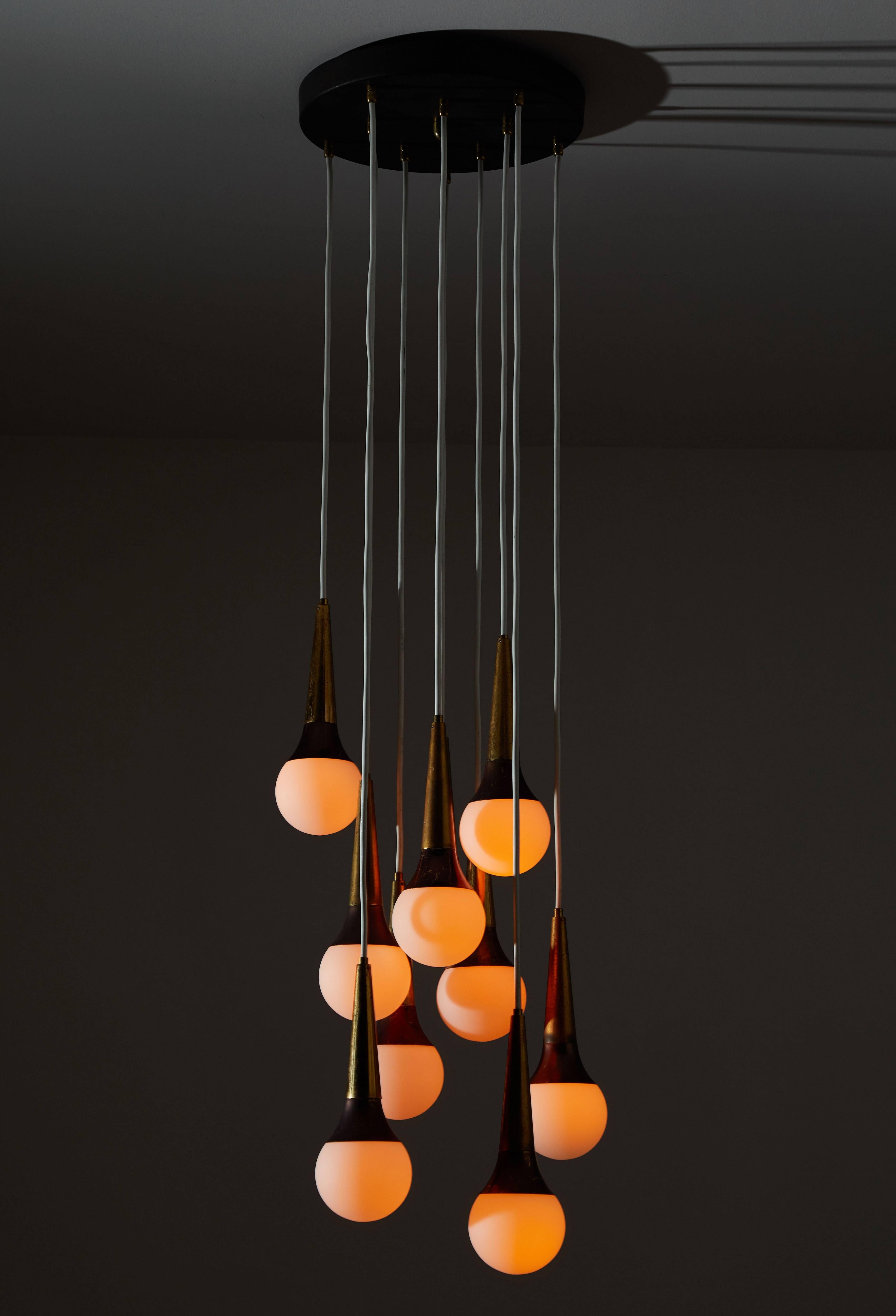 Nine-globe cascading chandelier by Stilnovo. Manufactured in Italy, circa 1960s. Brushed satin glass diffusers with brass hardware. Enameled metal canopy with cloth cords. Rewired for US junction boxes. Takes nine E14 European candelabra bulbs.