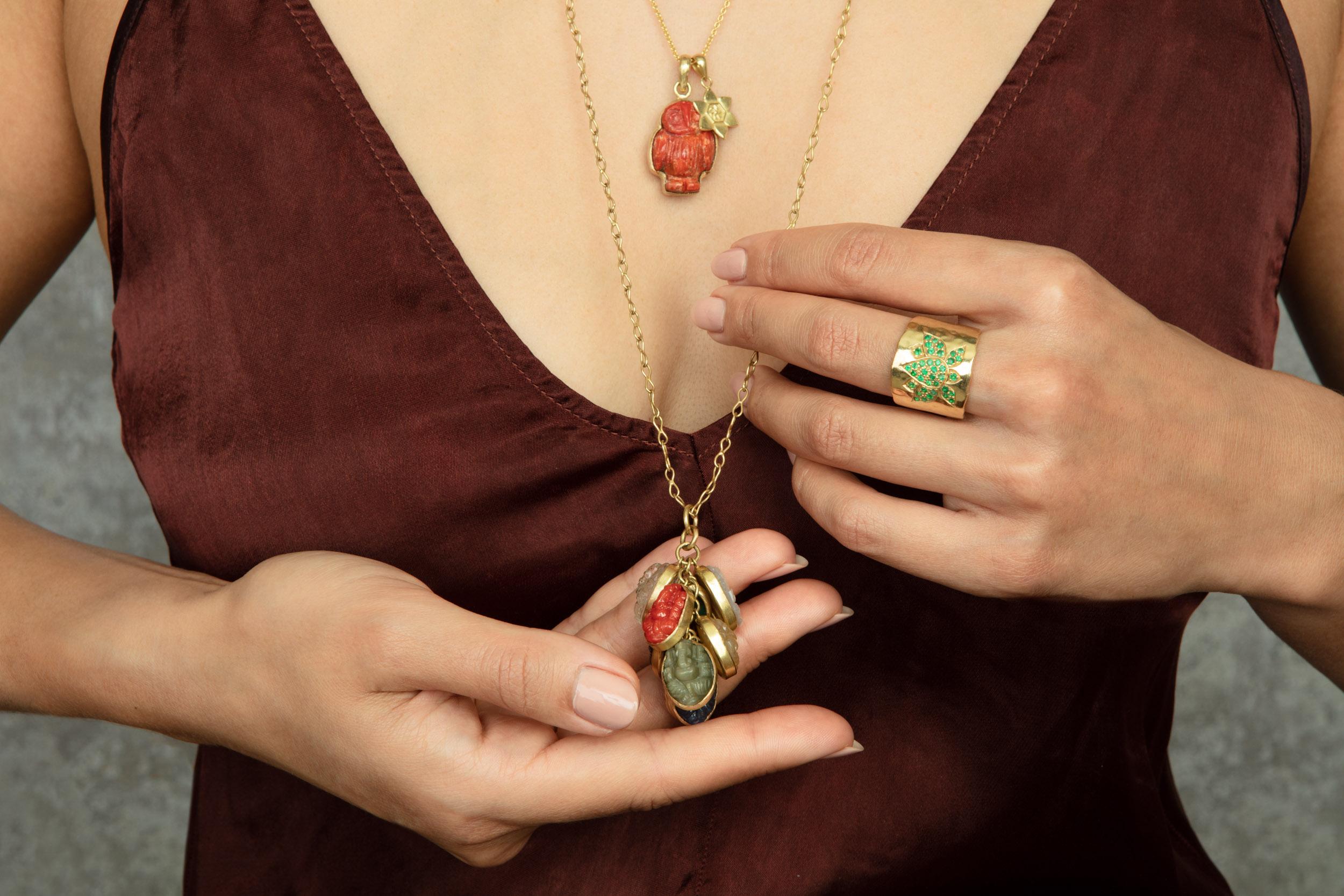 Nine hand-carved Ganesha set in 18 karat gold and cascading into one waterfall pendant, hanging on a 30