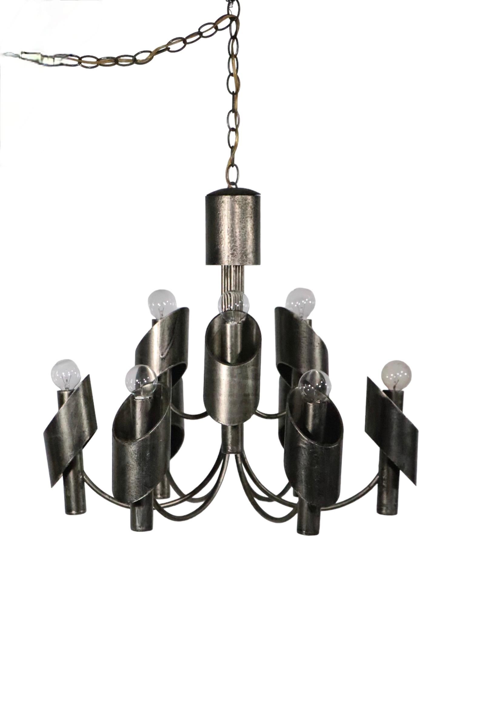 Exceptional Brutalist chandelier by Marcello Fantoni, circa 1970's. The fixture features nine uplight candle sockets, three interior and 6 exterior rings,  which surround the center point. The chandelier is circular ( 24.5 in Dia. x 21 in. H ) and