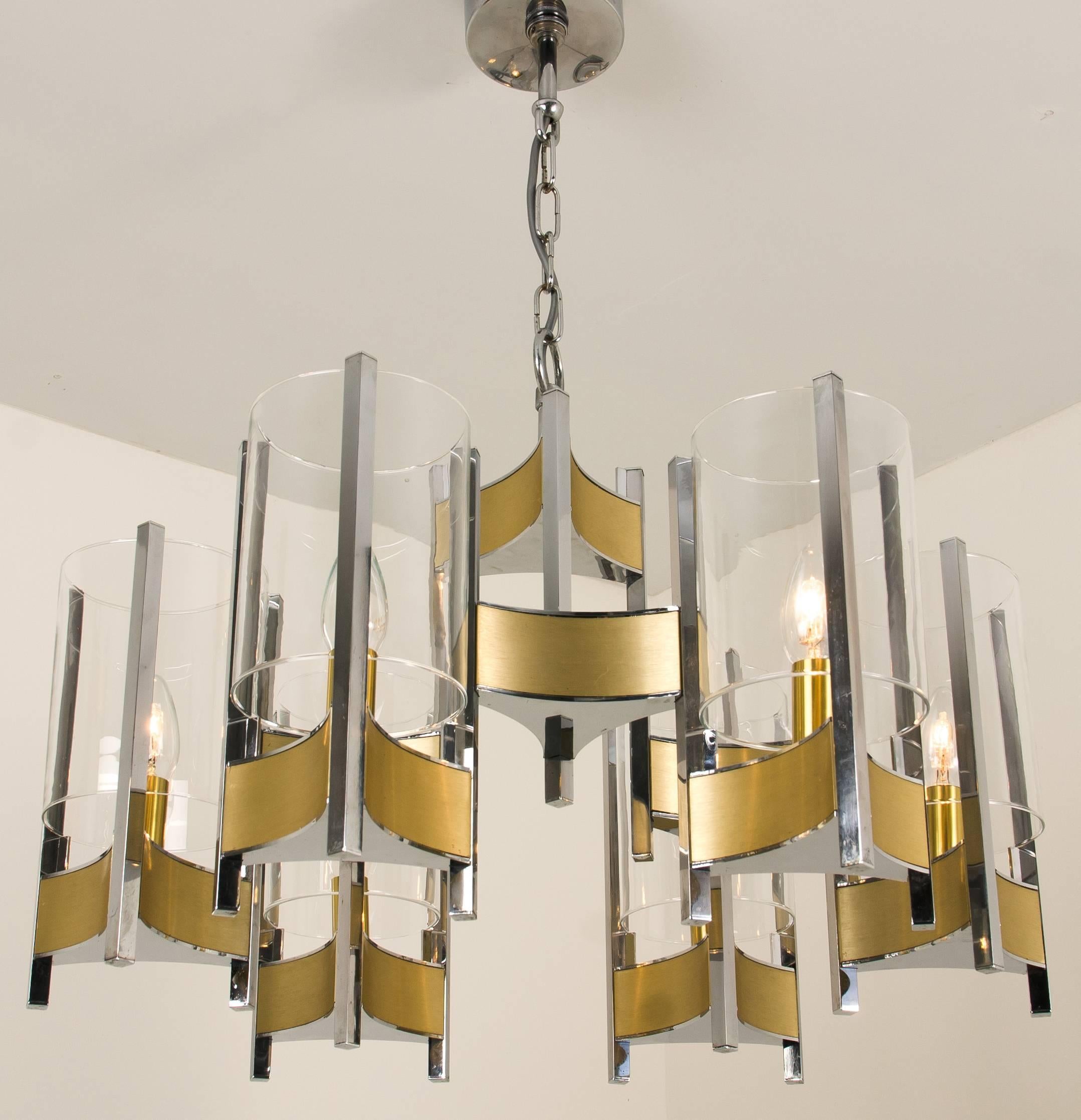 Gaetano Sciolari chrome and brushed brass two-tier nine-light chandelier with cylindrical glass shades, stylish monumental Sciolari chandelier. Consist of three arms with glass cylinders. Chrome and brushed brass base.

Cleaned and well-wired, in