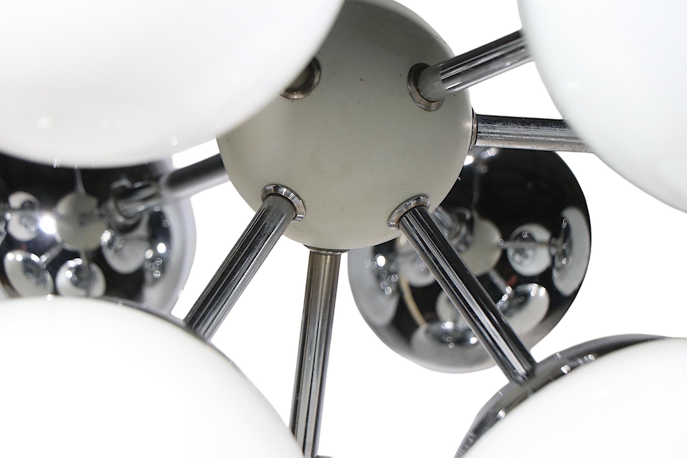 Lustre Chic Mid Century, Space Age, Post Modern en chrome Sputnik, avec neuf boules blanches.  les abat-jour en forme de globe - montés sur les bras à rayons chromés, tous attachés au centre de la boule blanche. L'appareil est en très bon état,