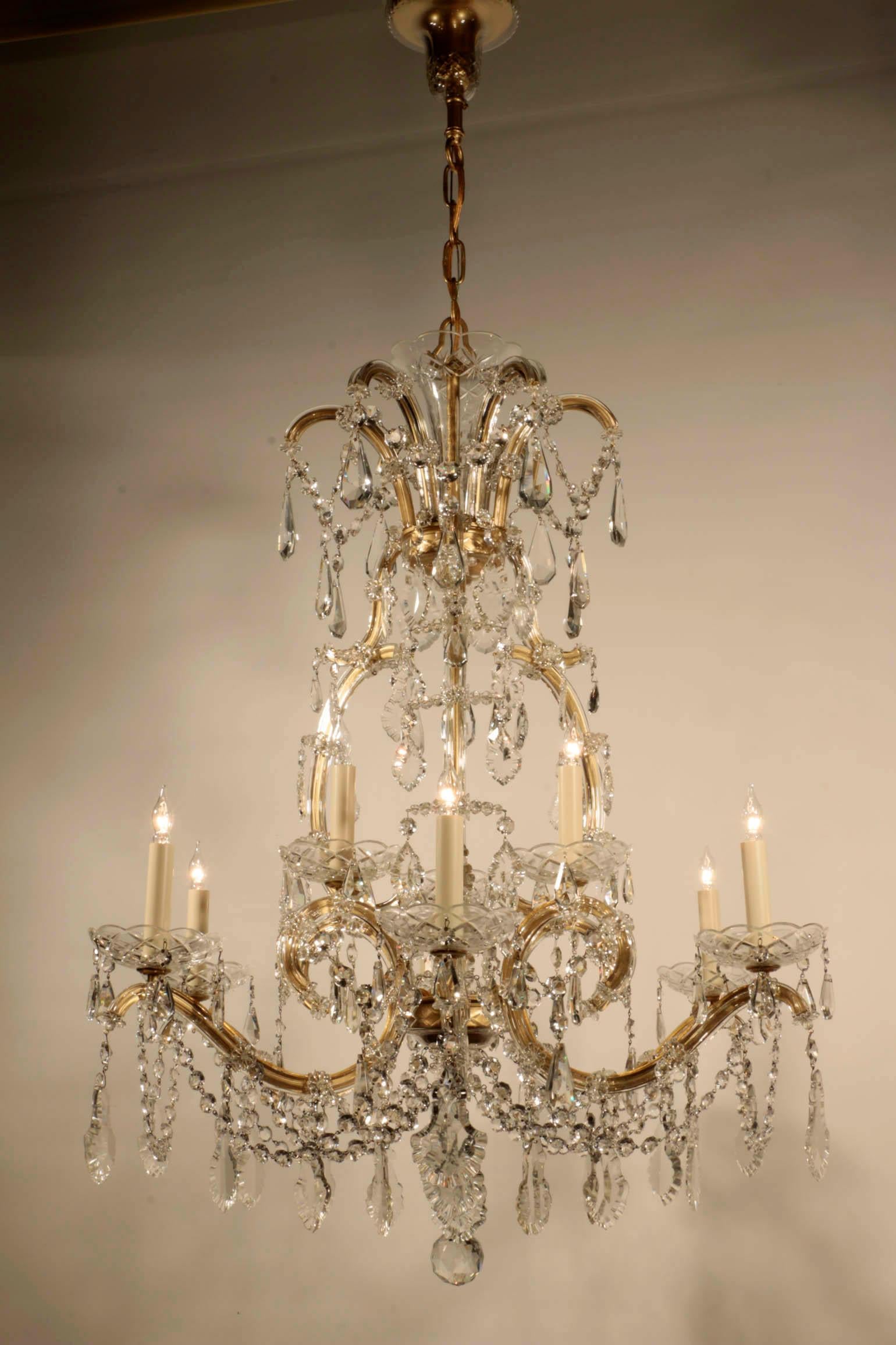 A vintage Czechoslovakian Marie-Therese cut crystal chandelier. The upper tier with three lights, the lower tier six, the whole profusely hung with drops, hanging beads and French style pendaloques crystals.
This wonderful fixture illuminates itself