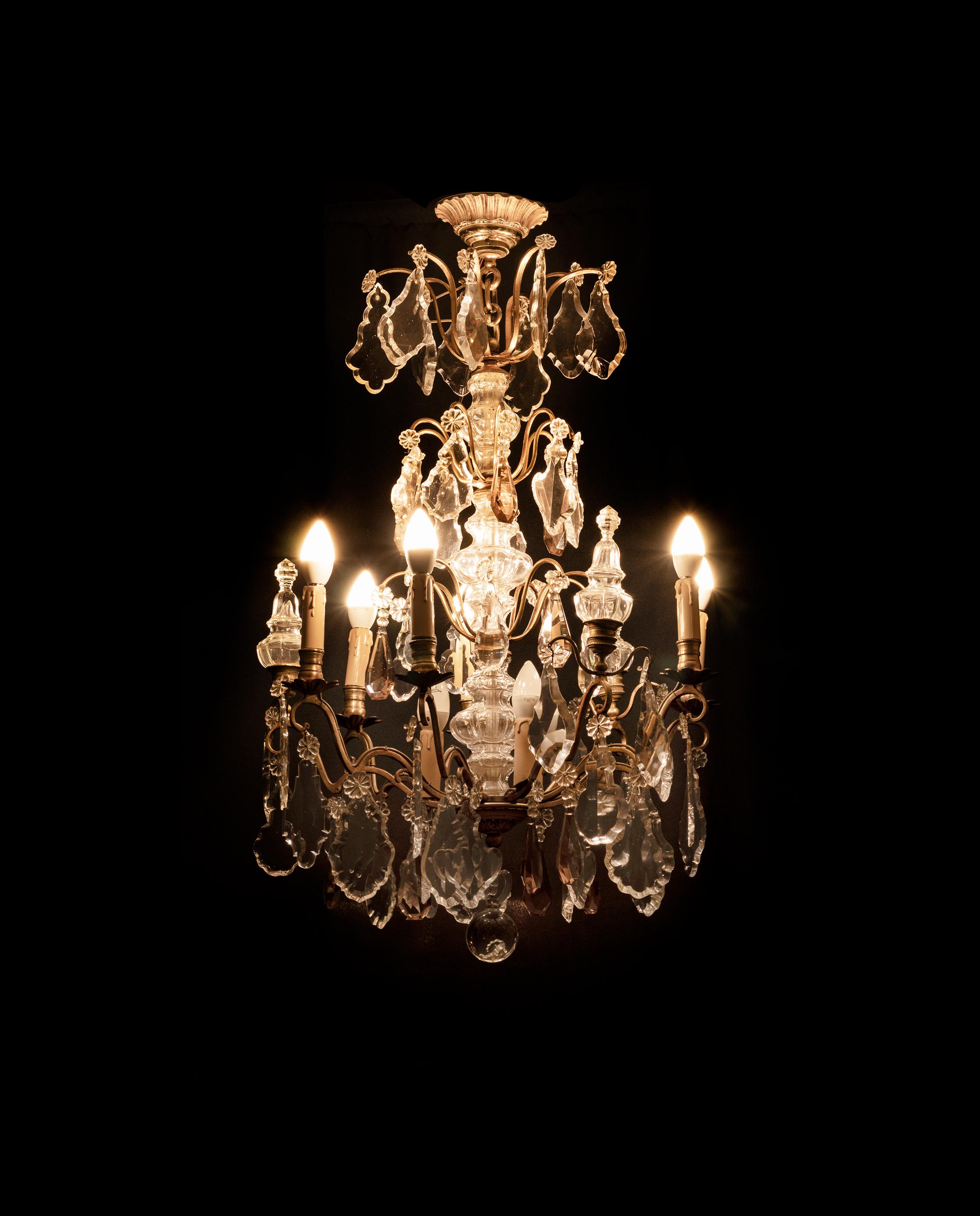  A Louis XV-Style bronze chandelier with crystal pendants and finials
and tinted glass, completed and rewired with candlestick holders and nine light sockets.

The chandelier is currently wired for both European Union and US standards LED lights.
