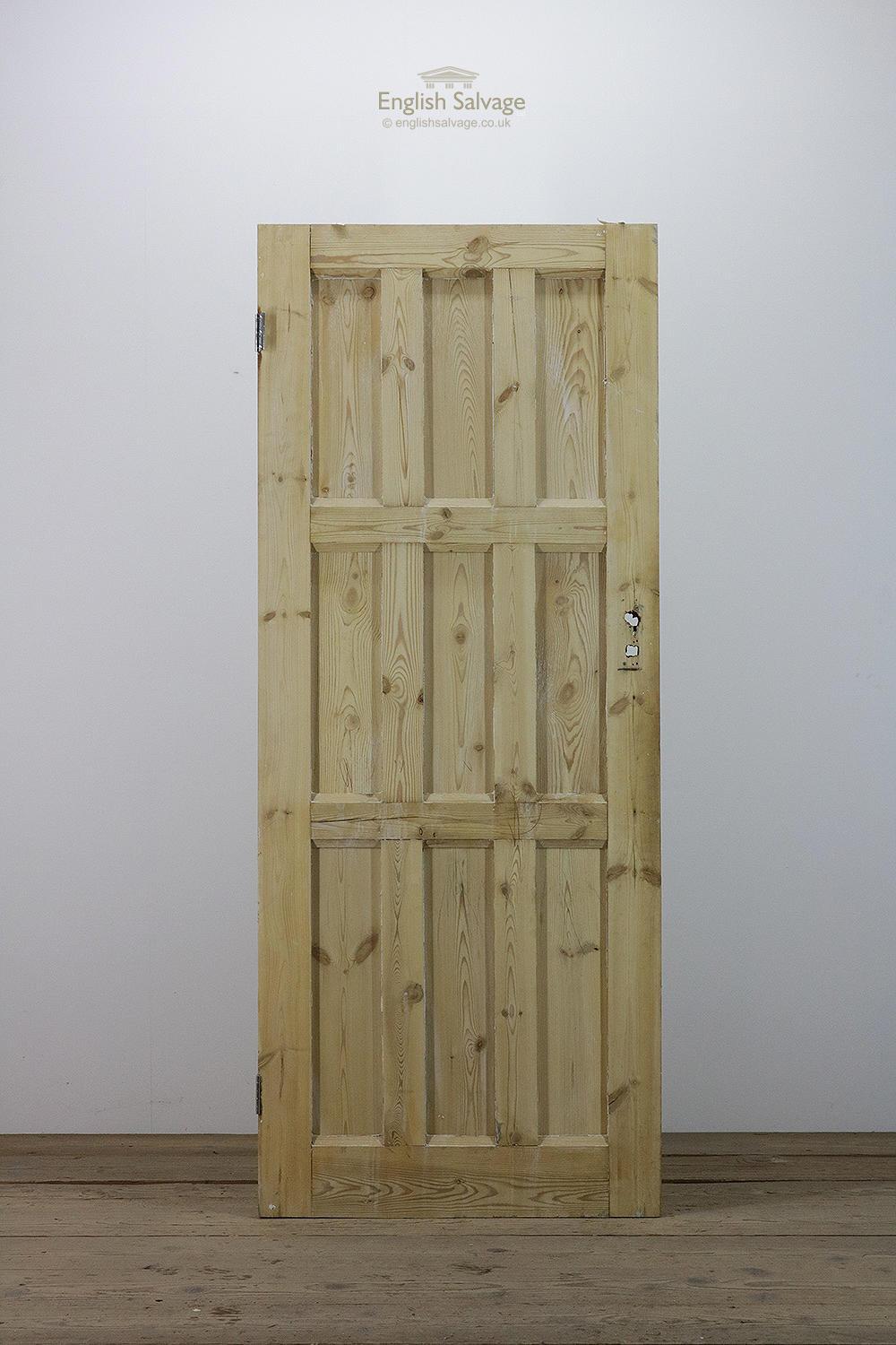 Reclaimed pine interior door with nine vertical panels and two hinges. Lock, handle and nail holes as well as a few marks from dipping and remnants of old paint.