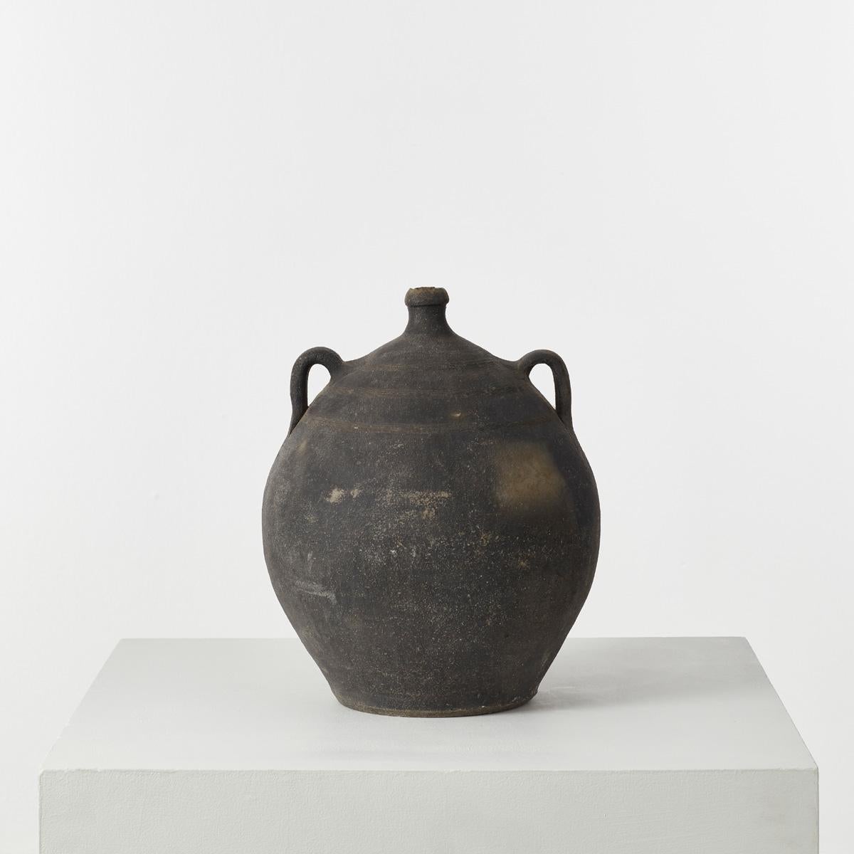 This black terracotta Cosi pot was crafted in the village of Quart in the Girona region of Catalonia in the 1800s. Its original function was to contain wine or olive oil. It possesses a beautiful, organic form and a dusky matte patina akin to