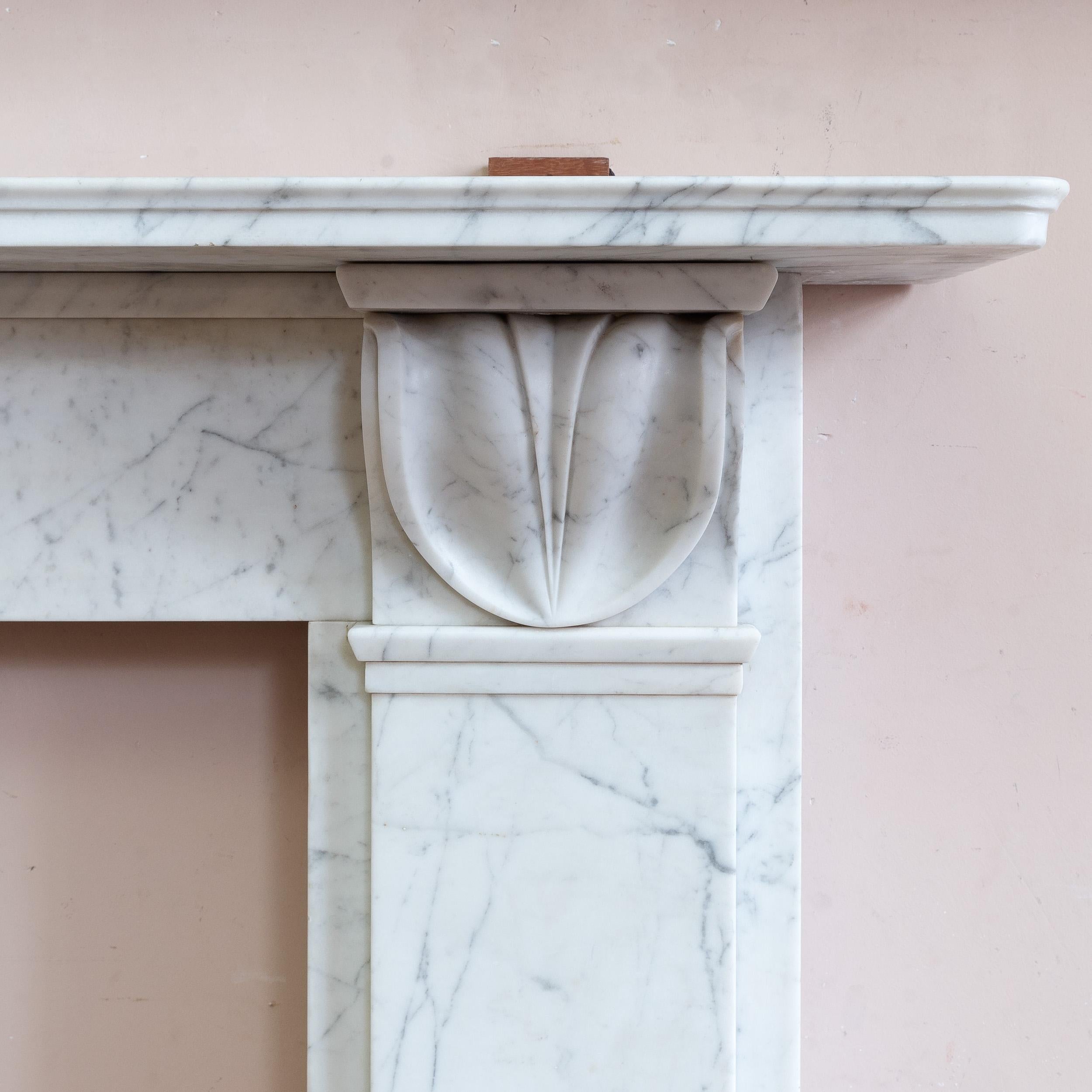 Nineteenth century English Carrara marble fireplace, c.1830, with lamb's tongue corbels supporting the shelf, all on pilaster jambs.

Dimensions:	119.5cm (47