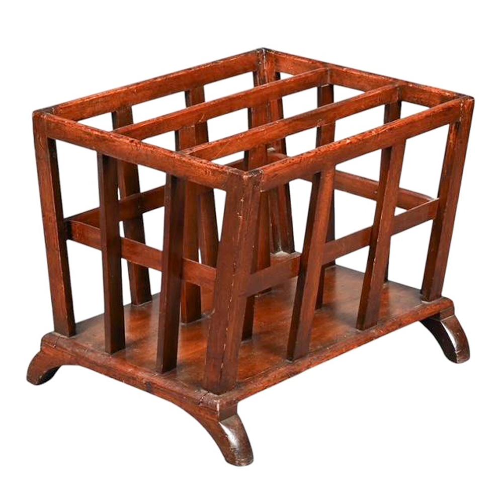 Canterbury in mogano di forma rettilinea con lati angolati ed estremità verticali dritte che si ergono da una base piatta in mogano sollevata su gambe ad arco. I fianchi e i divisori sono costituiti da elementi verticali piatti incastrati nella base