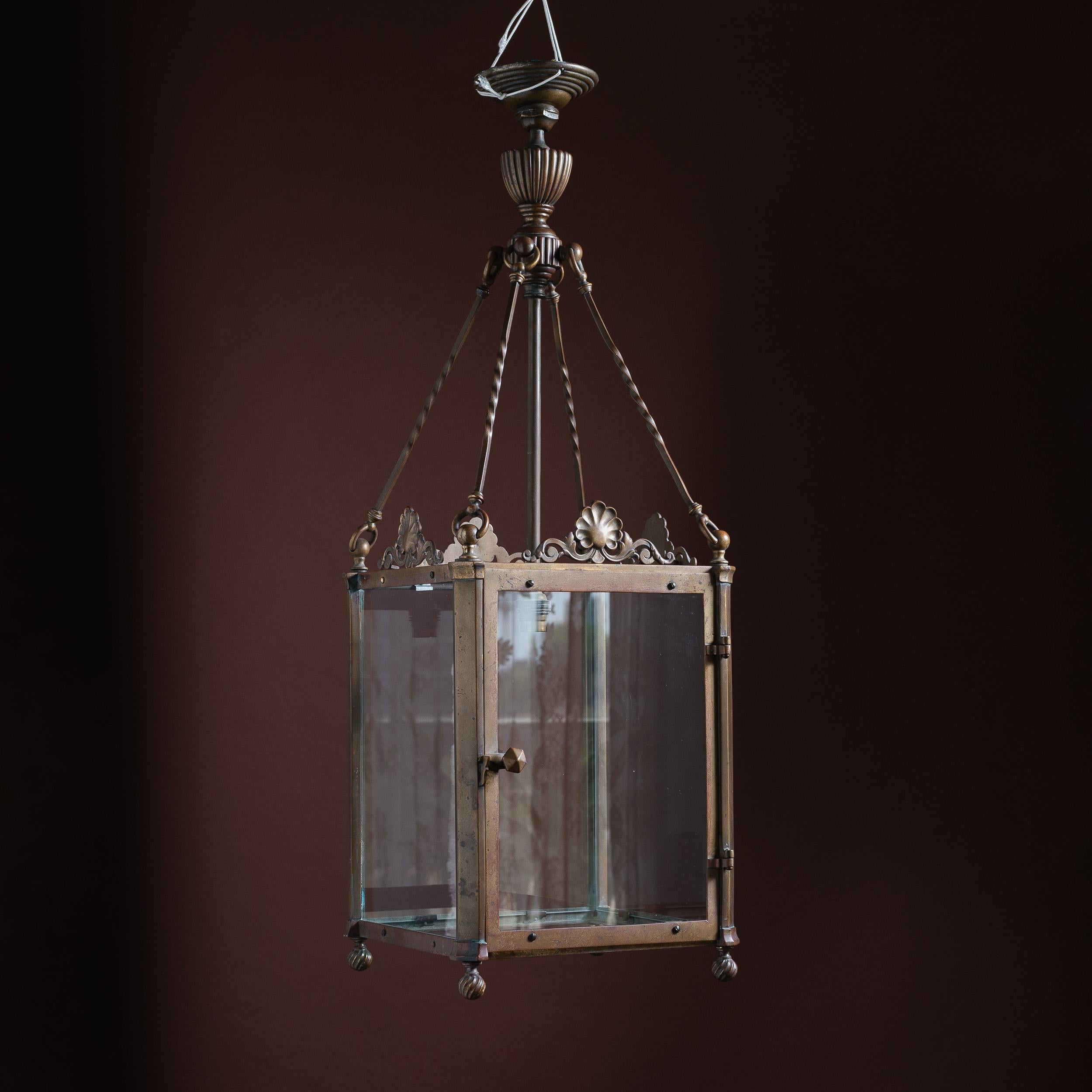 Lanterne de hall en laiton patiné du XIXe siècle, historiquement convertie au gaz, vitrée et dotée d'une seule lumière intérieure, chaque côté étant orné d'une coquille Saint-Jacques et d'une crête feuillagée. Actuellement monté au plafond, un