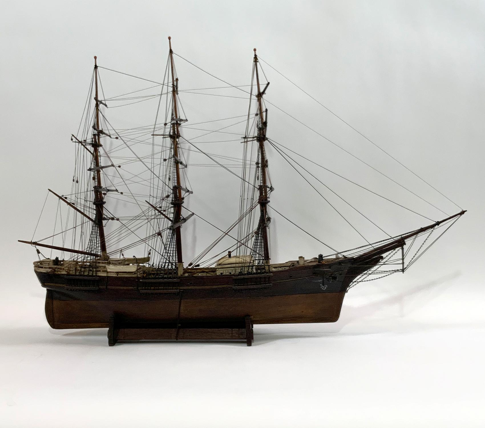 Fine period model showing a classic windjammer. Carved lifeboats hang from davits. Two more lifeboats are on the cabin roof. Scribed and varnished deck. Rigged with a full set of standing and running cords. Interesting carved cradle with extra