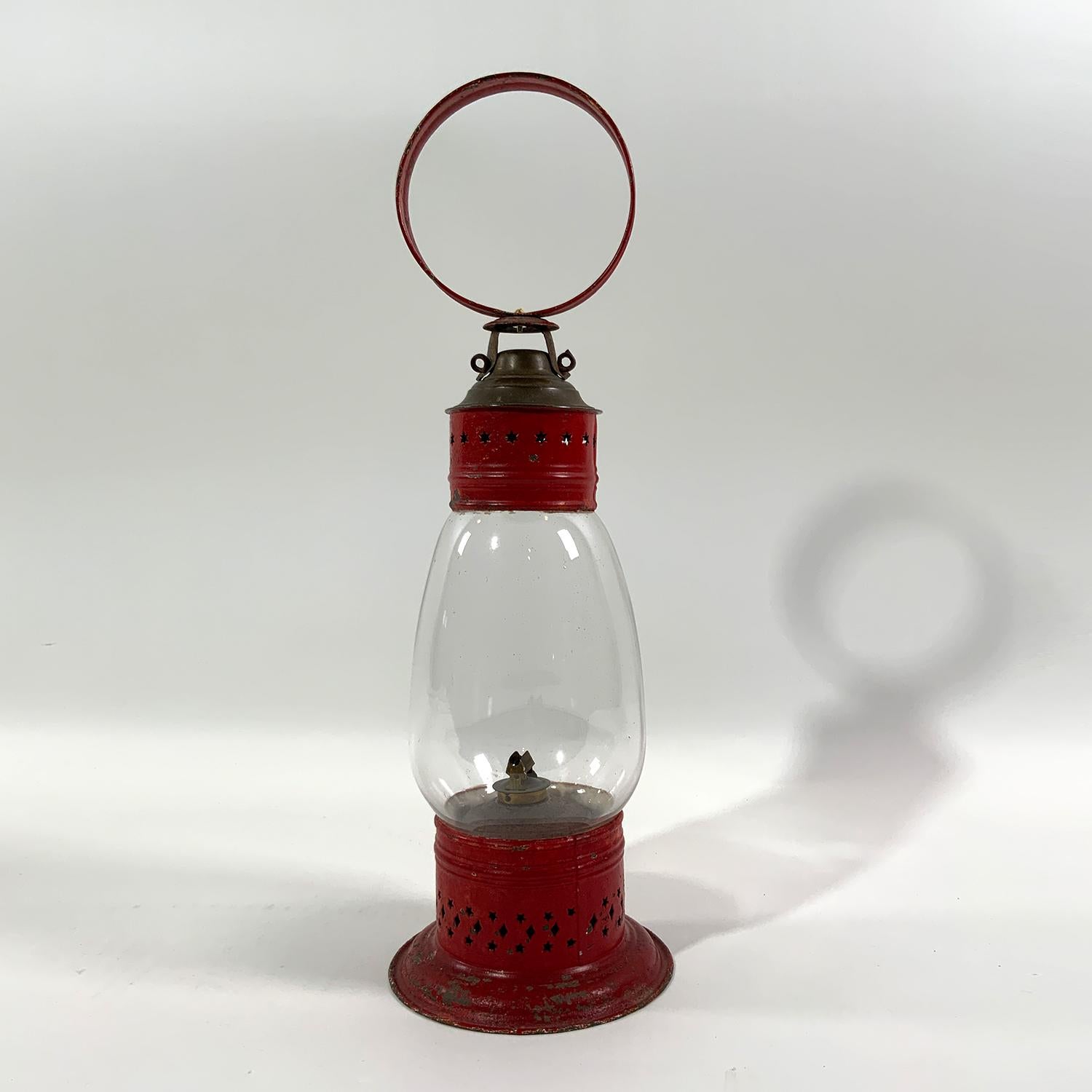 Lampe de pont de navire du XIXe siècle avec poignée en boucle, brûleur à huile avec réservoir et globe en verre. La cheminée ventilée est percée d'étoiles. Vers 1865.