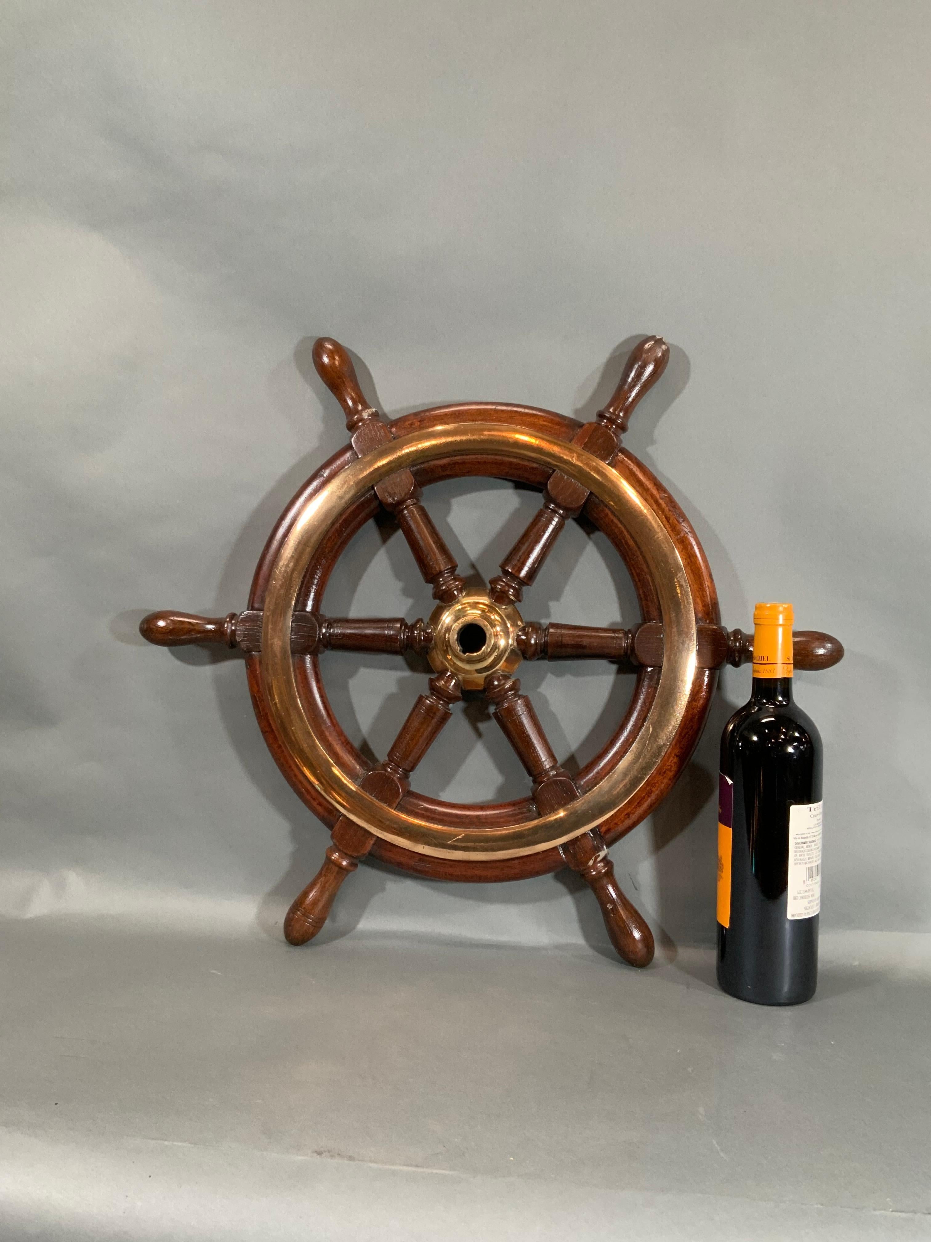 Antique boat wheel from a yacht circa 1890. With highly polished brasses, six turned spokes, the outer ring is heavy brass. This is an exceptional helm.

Overall dimensions: Weight is 12 pounds. 24