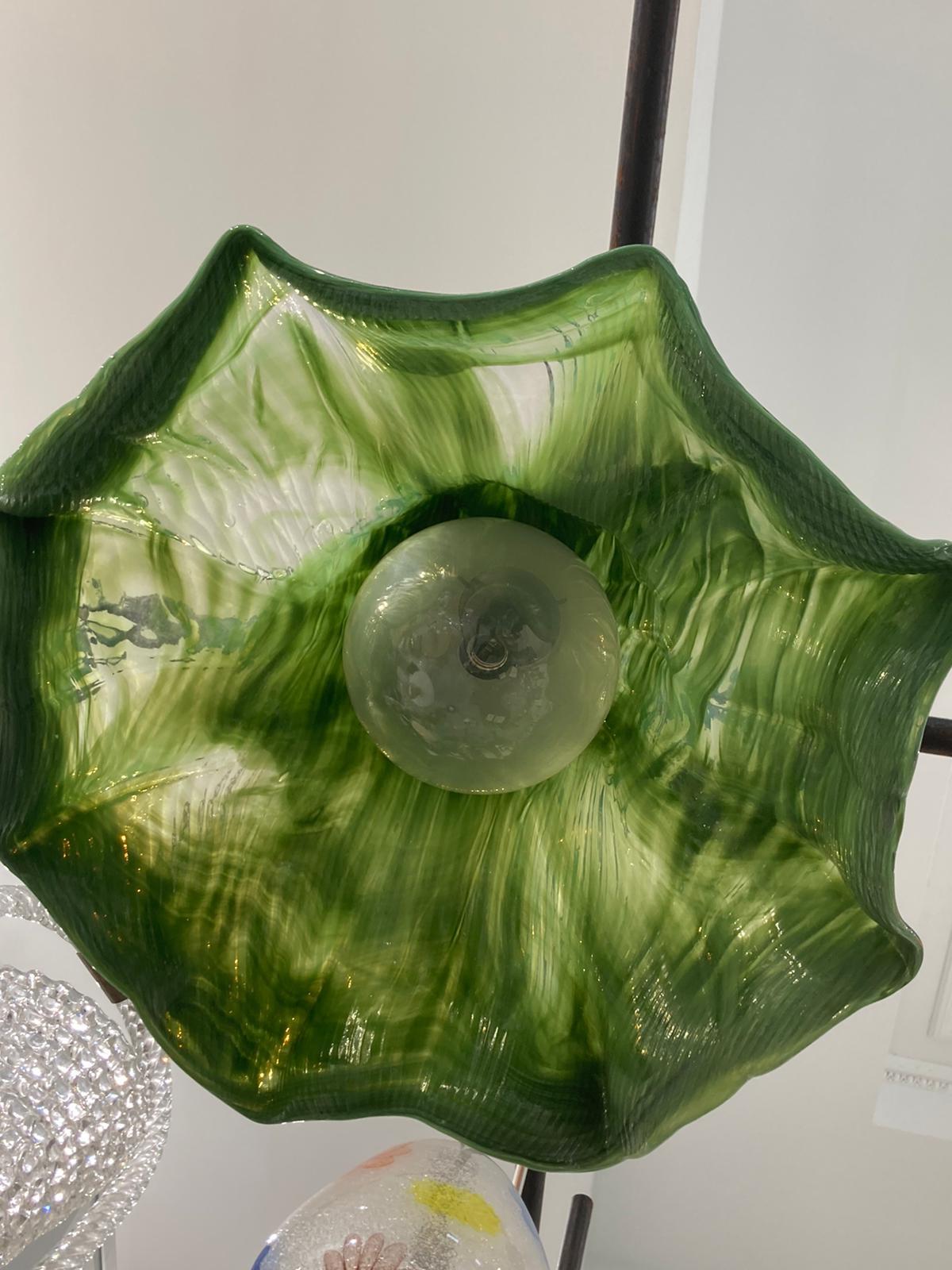 Lampe à suspension Ninfea conçue par Toni Zuccheri pour Venini en 1970.
Le pendentif en verre soufflé de Murano, d'un vert émeraude profond, est traversé par des marbrures de verre clair et blanc, créant ainsi différents niveaux de transparence