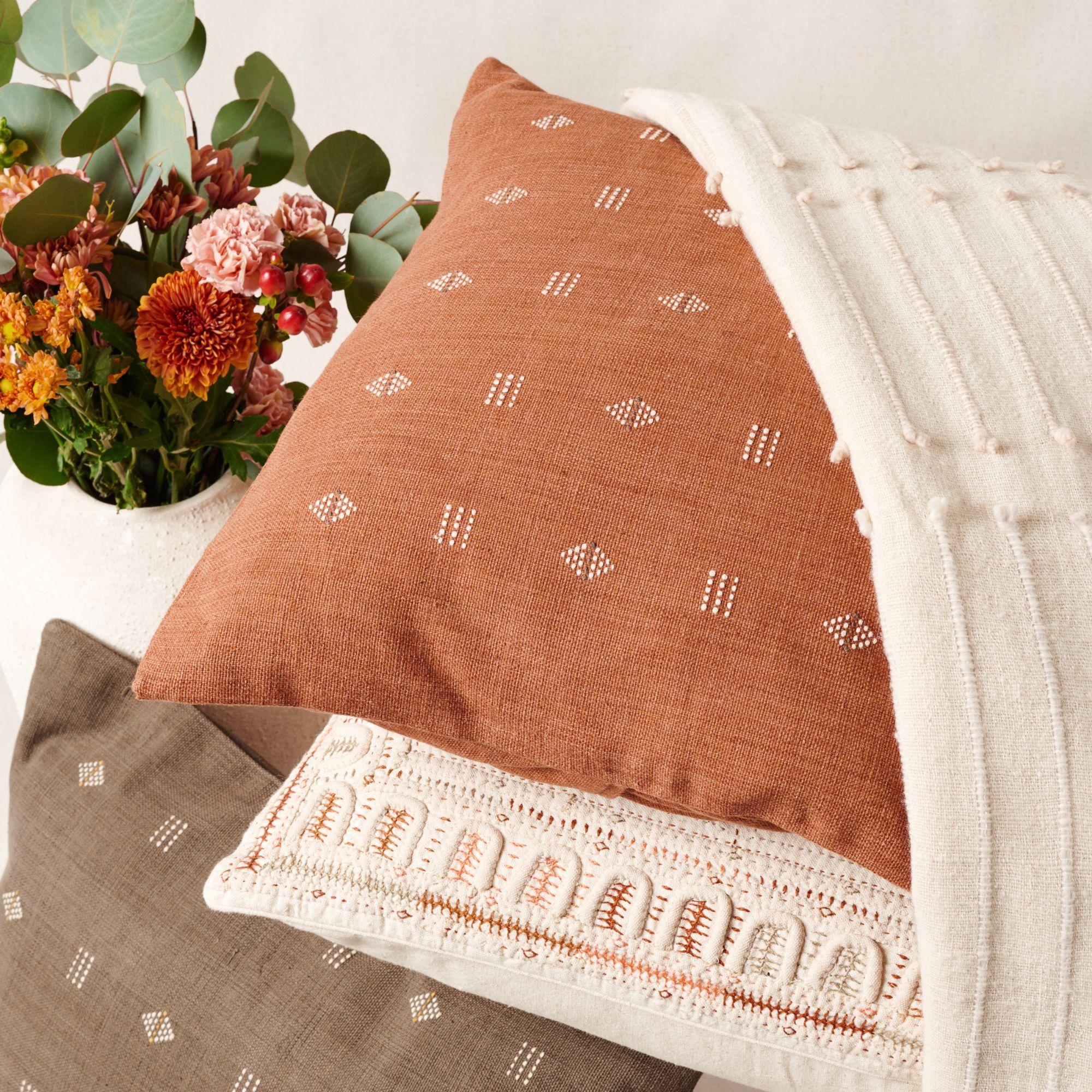 Nira Brown Pillow is a slightly textured handwoven pillow where our artisans have skillfully created a classic pattern using an ancient weaving technique. Undyed yarn is used as a design element with the backdrop of pleasant hues of terra-cotta