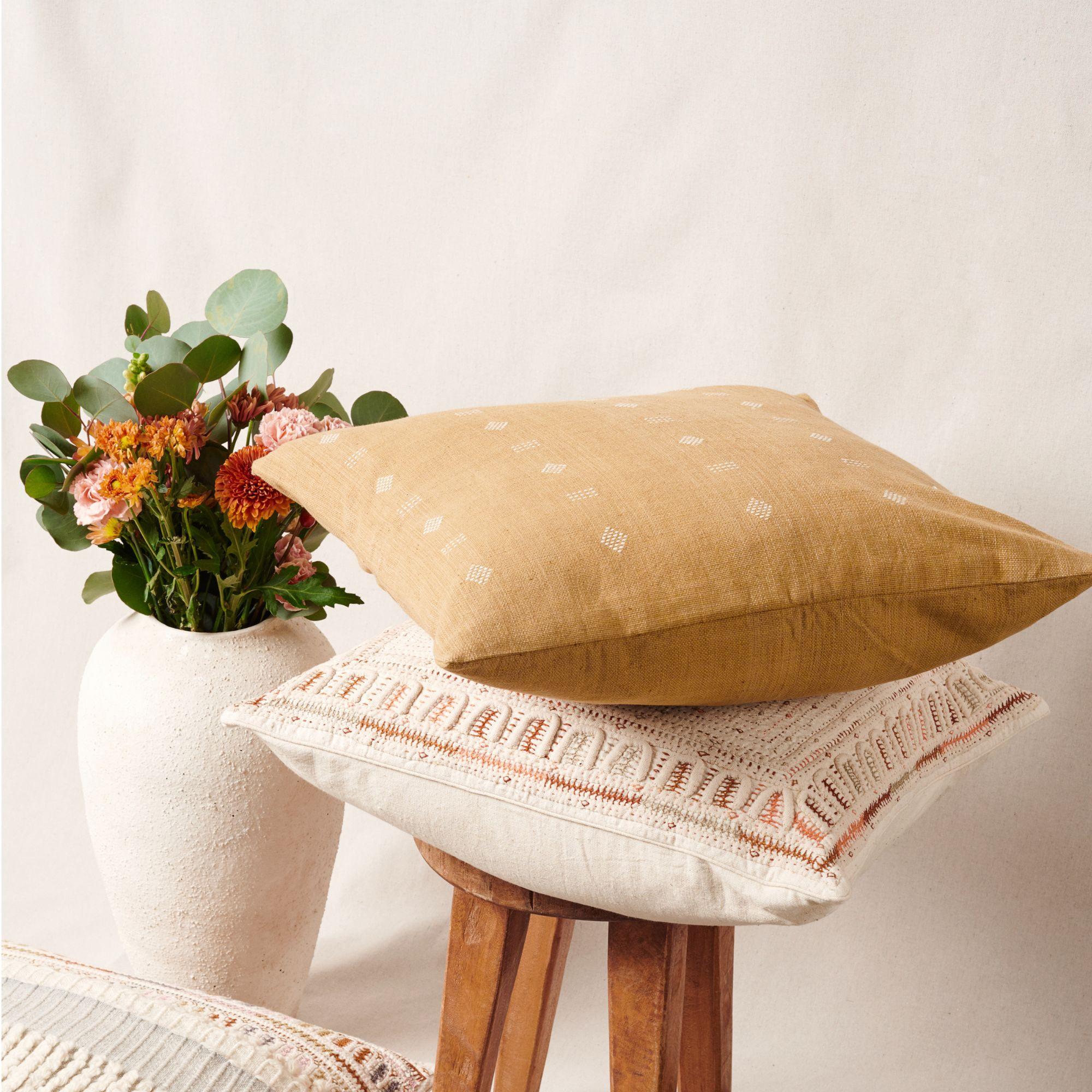 Nira Ochre Pillow is a slightly textured handwoven pillow where our artisans have skillfully created a classic pattern using an ancient weaving technique. Undyed yarn is used as a design element with the backdrop of pleasant hues of ochre yellow.