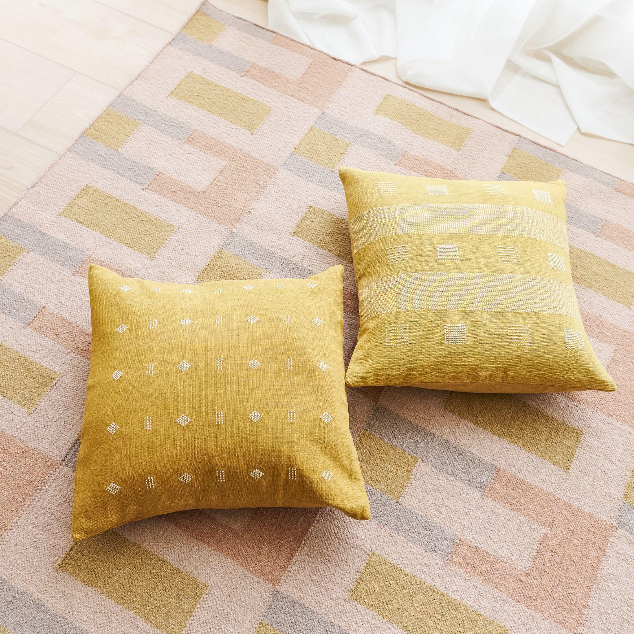 L'oreiller Nira Ochre est un coussin tissé à la main légèrement texturé où nos artisans ont habilement créé un motif classique à l'aide d'une ancienne technique de tissage. Le fil non teinté est utilisé comme élément de conception pour former la