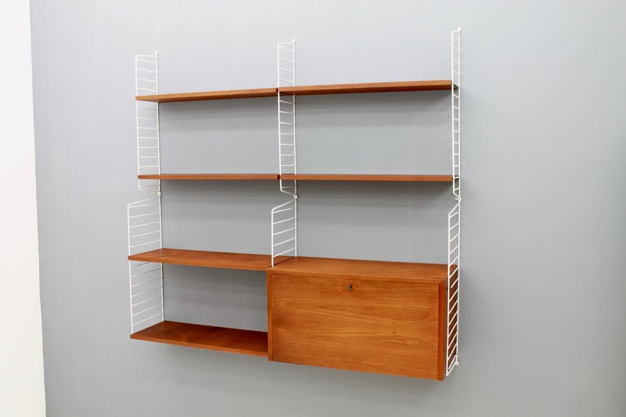 Wall system by Nisse Strinning in teak wood and white wall holders. One writing cabinet and six shelves. Very good condition.



Nisse Strinnings designs should always be mentioned in connection with the work of his wife Kajsa Strinning. She was