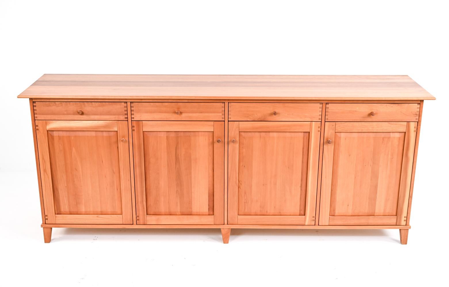 Danish ingenuity and the finest craftsmanship meet in this spectacular sideboard made from solid cherry wood, with four drawers and four shelved cupboards, the cupboard doors crafted with unusual wood hinges to match the finger joinery of the