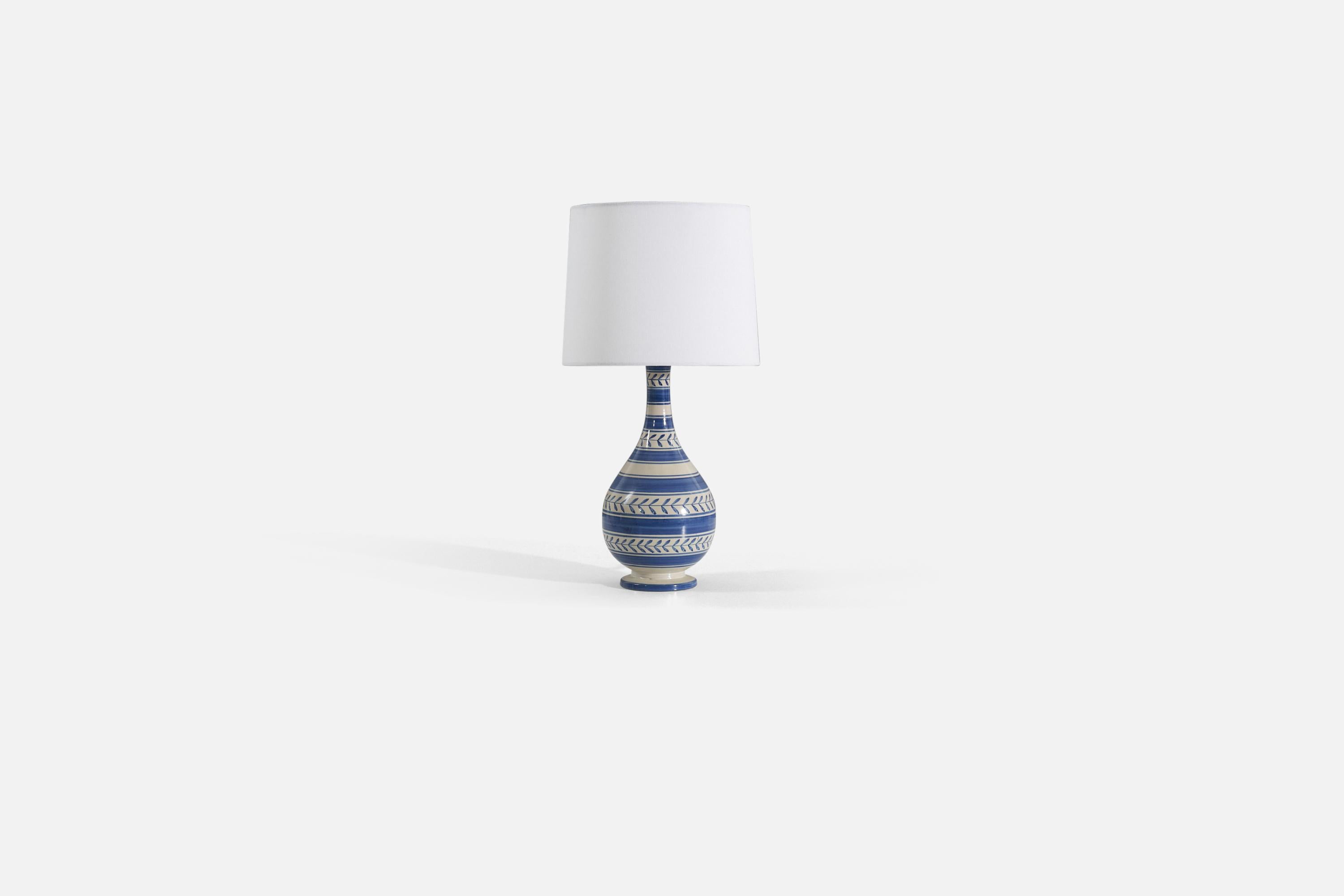 A blue and white glazed earthenware table lamp produced by Nittsjö, Sweden, 1940s. 

Sold without lampshade. Stated dimensions exclude the lampshade. Height includes socket. 

For reference:
Shade : 9 x 10 x 8 
Lamp with shade : 19.75 x 10 x 10