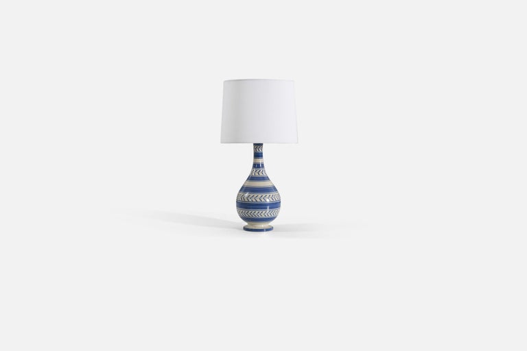 A blue and white glazed earthenware table lamp produced by Nittsjö, Sweden, 1940s. 

Sold without lampshade. Stated dimensions exclude the lampshade. Height includes socket. 

For reference:
Shade : 9 x 10 x 8 
Lamp with shade : 19.75 x 10 x 10