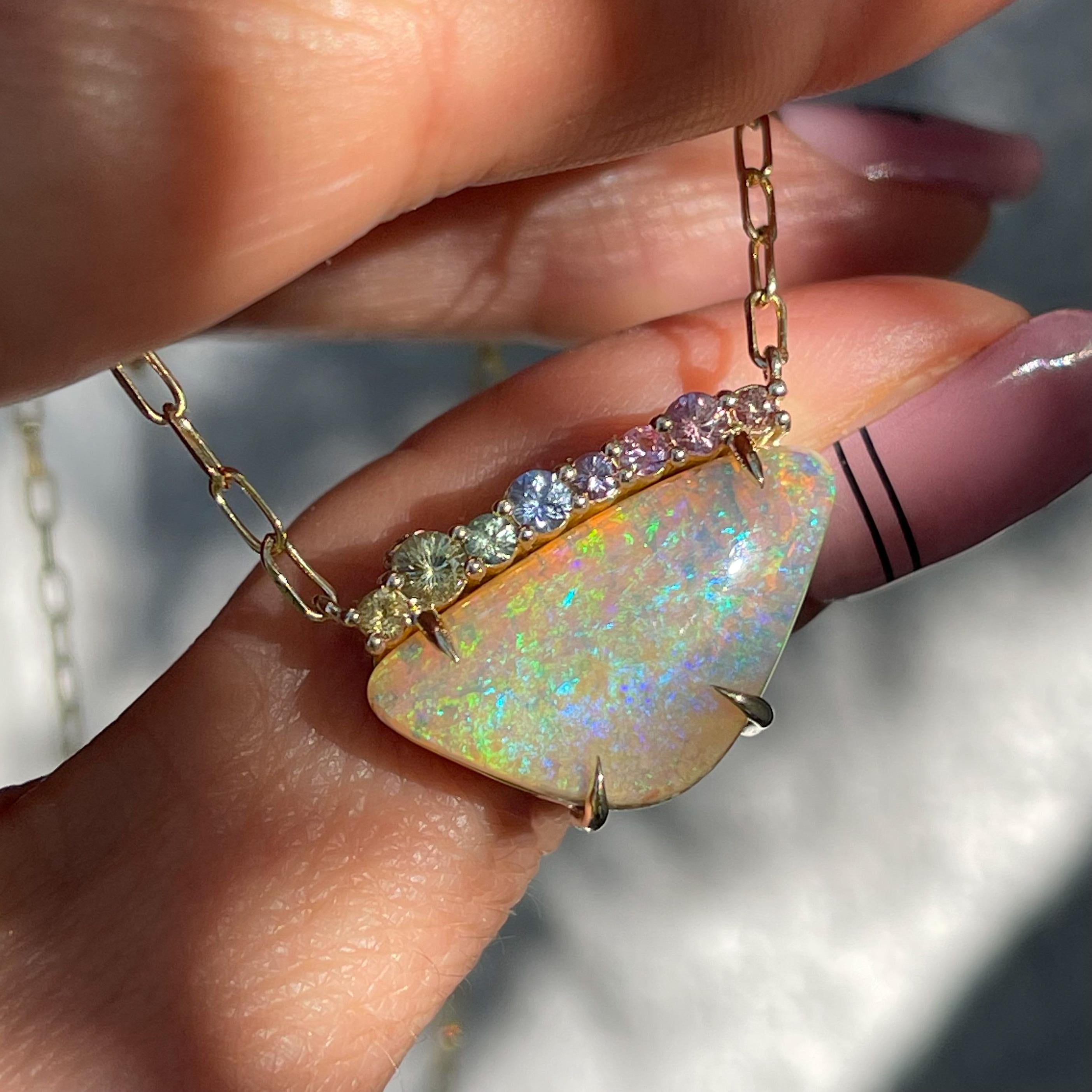 Swollen with color and ready to burst, this Australian Opal Necklace flexes its complexion. The 10 carat Pipe Opal and row of ombré sapphires coalesce in a rainbow palette, poised to reveal their splendor. At the base of the stone 3D masses form,