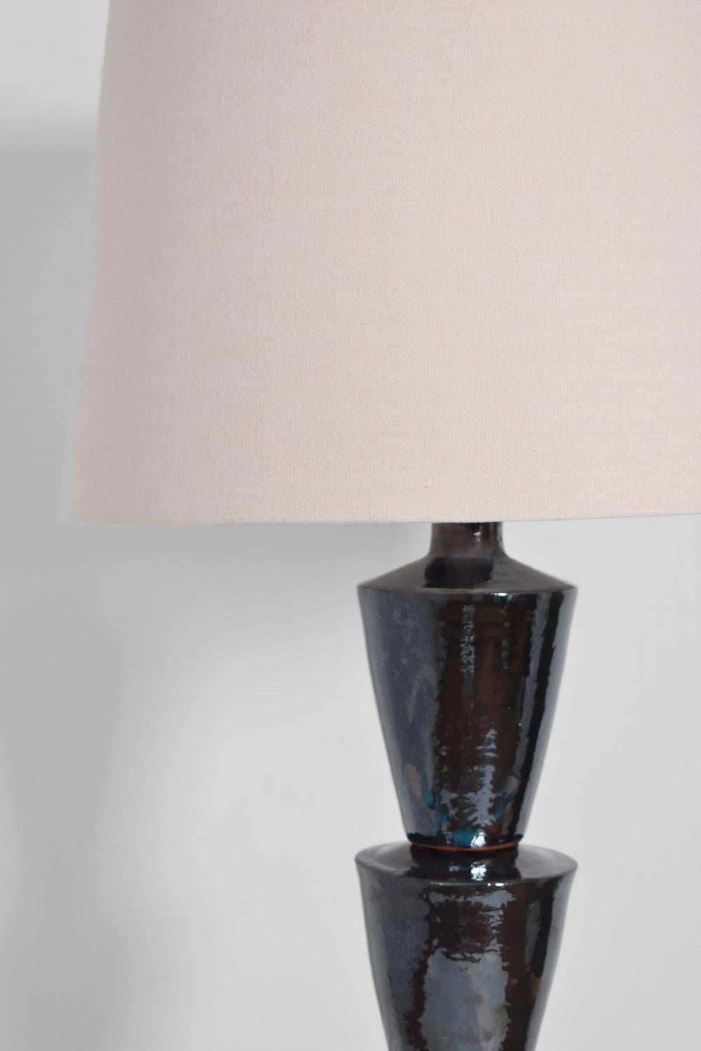 Lampada da terra in argilla nera di Nizwa che poggia su una base circolare in bronzo. Edizione Barracuda, realizzata in Portogallo.