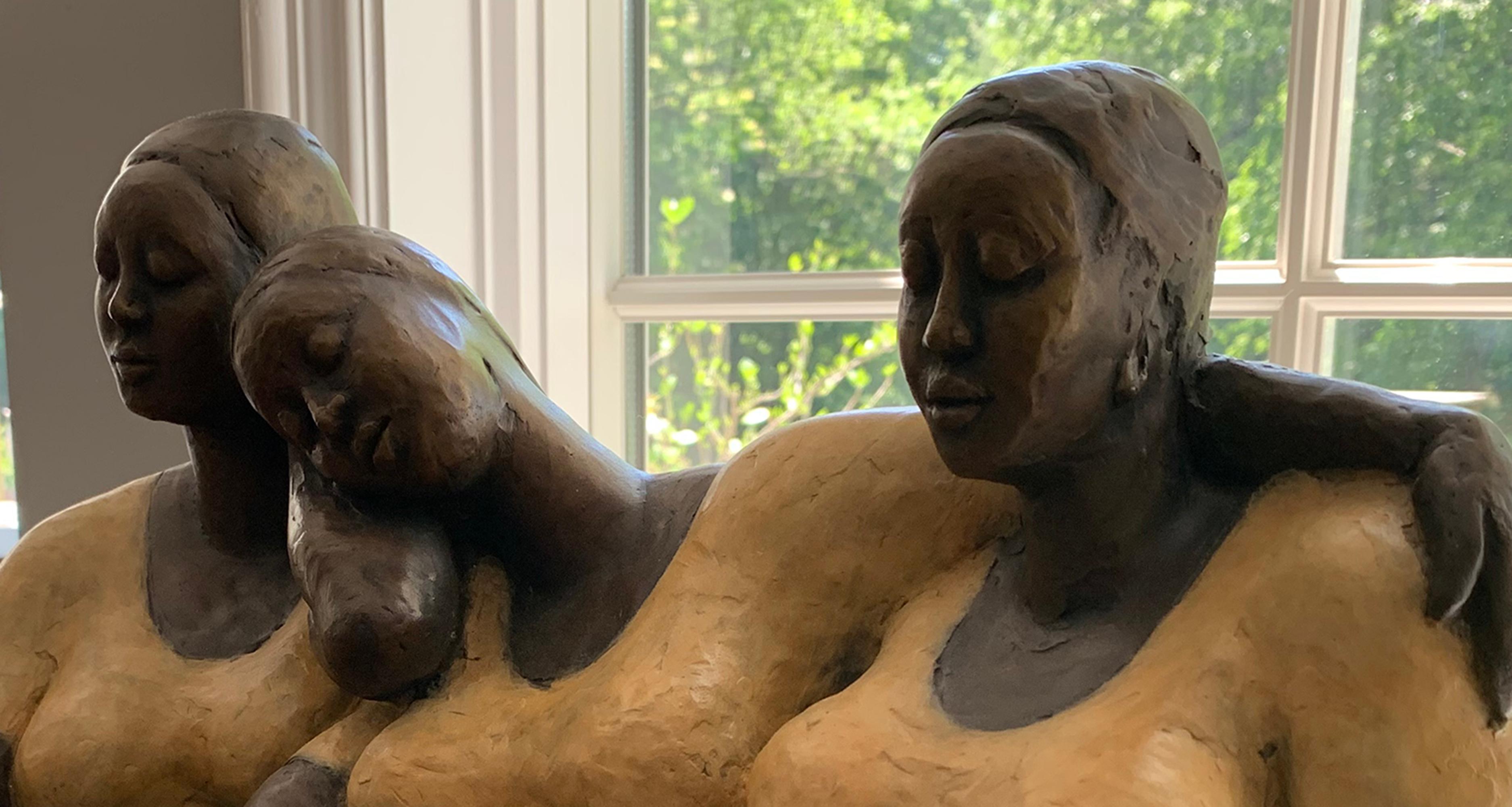 Mujer sentada estilizada de Nnamdi Okowkwo en actitud de tranquilidad. Para crearla, primero esculpe la figura en arcilla y luego la funde en bronce mediante la técnica de la cera perdida. La pátina en caliente se aplica utilizando compuestos