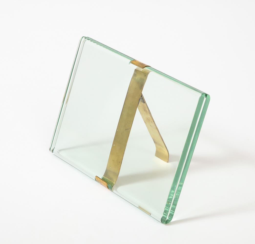 Glass, brass. Rare horizontal tabletop frame designed by Pietro Chiesa for Fontana Arte. Elegant polished crystal panels with brass-banded fittings and stand.
Vertical version available also.